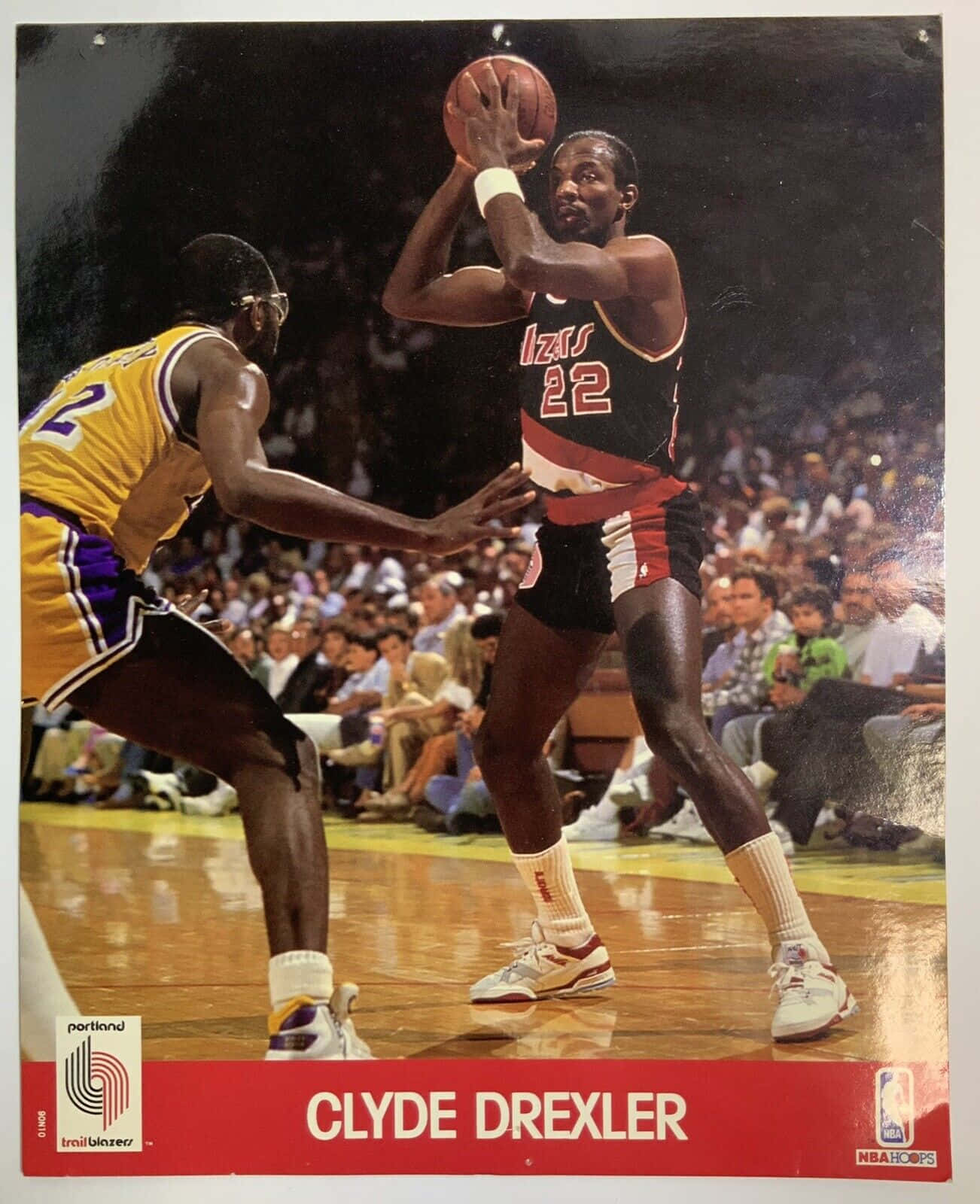 克萊德·德雷克斯勒22號波特蘭開拓者隊賽事攝影 壁紙 — Clyde Drexler 身穿波特蘭拓荒者球衣，在滿座的球場中準備投籃，同時被湖人球員防守。