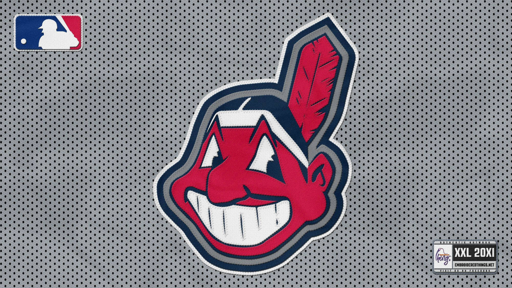 克里夫蘭印第安人隊 Chief Wahoo 設計 壁紙 — 一個紅色卡通美洲原住民吉祥物標誌，帶有羽毛，背景為灰色網眼棒球球衣。