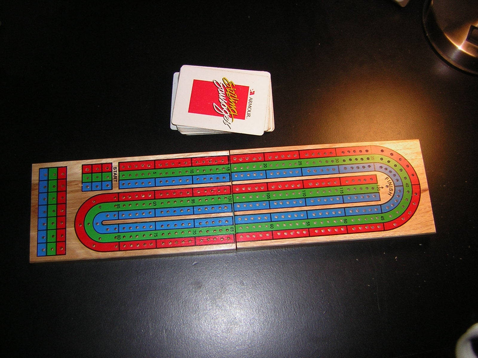深色枱面上嘅 cribbage 板同一副啤牌。