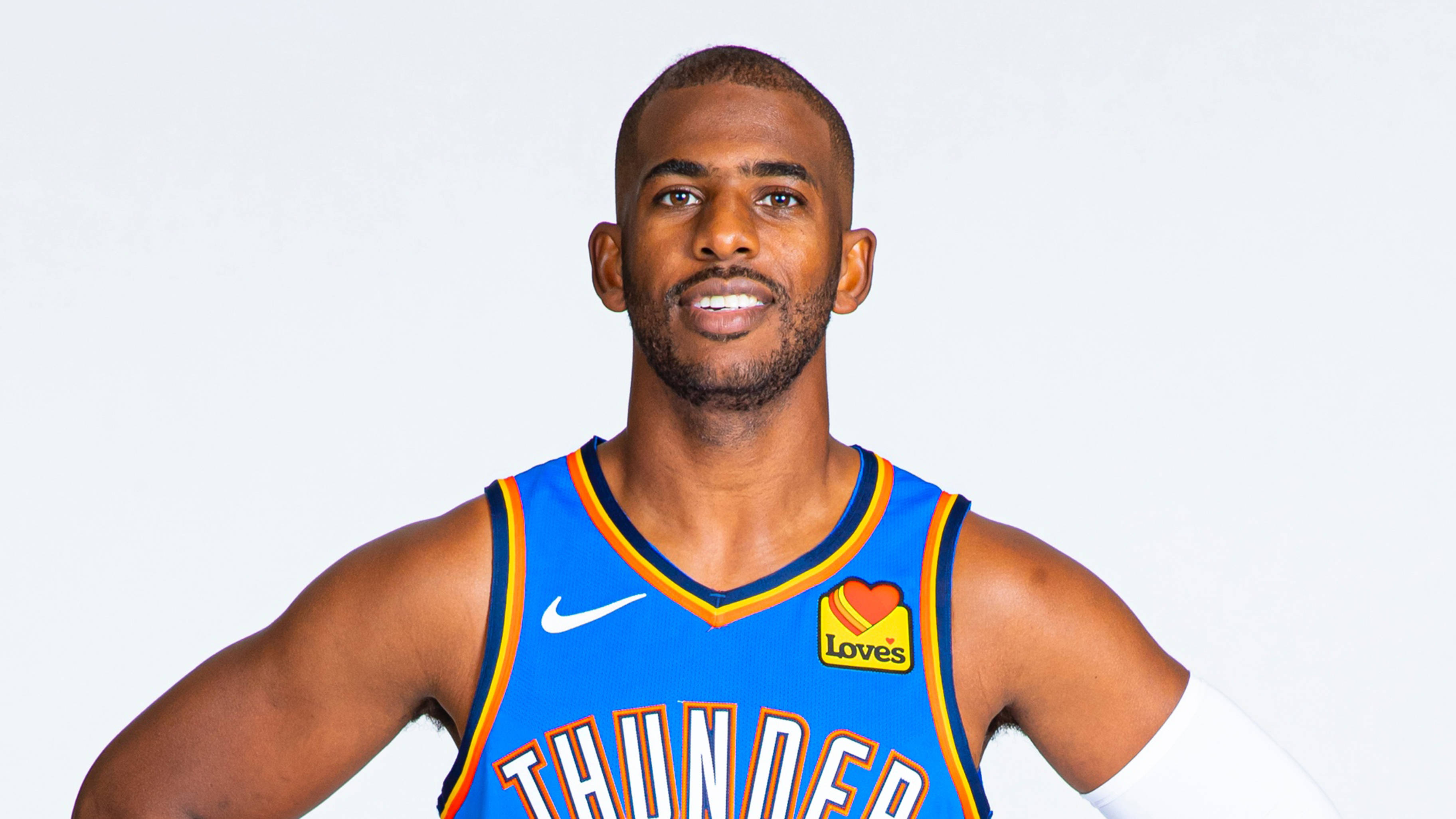 克里斯·保羅OKC藍色球衣 壁紙 — 一位自信的籃球運動員身穿藍色奧克拉荷馬城雷霆隊球衣，在純白色背景前擺姿勢。