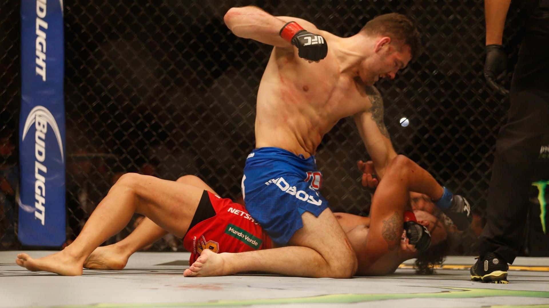兩名MMA拳手在UFC八角籠內纏鬥，其中一人發出肘擊。