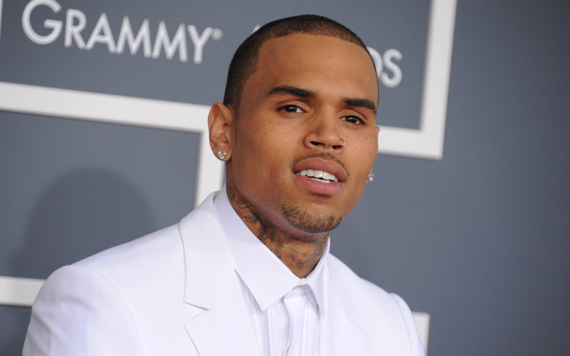 克里斯·布朗 格萊美獎近照 壁紙 — Chris Brown 身穿利落白色西裝，在葛萊美獎紅地毯上自信微笑。
