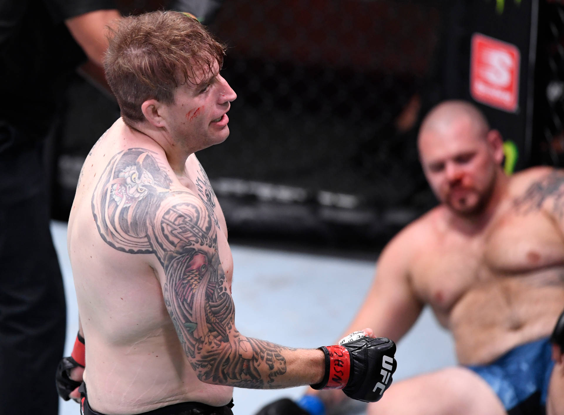 紋身MMA拳手滿臉鮮血，在八角籠中勝利站立。