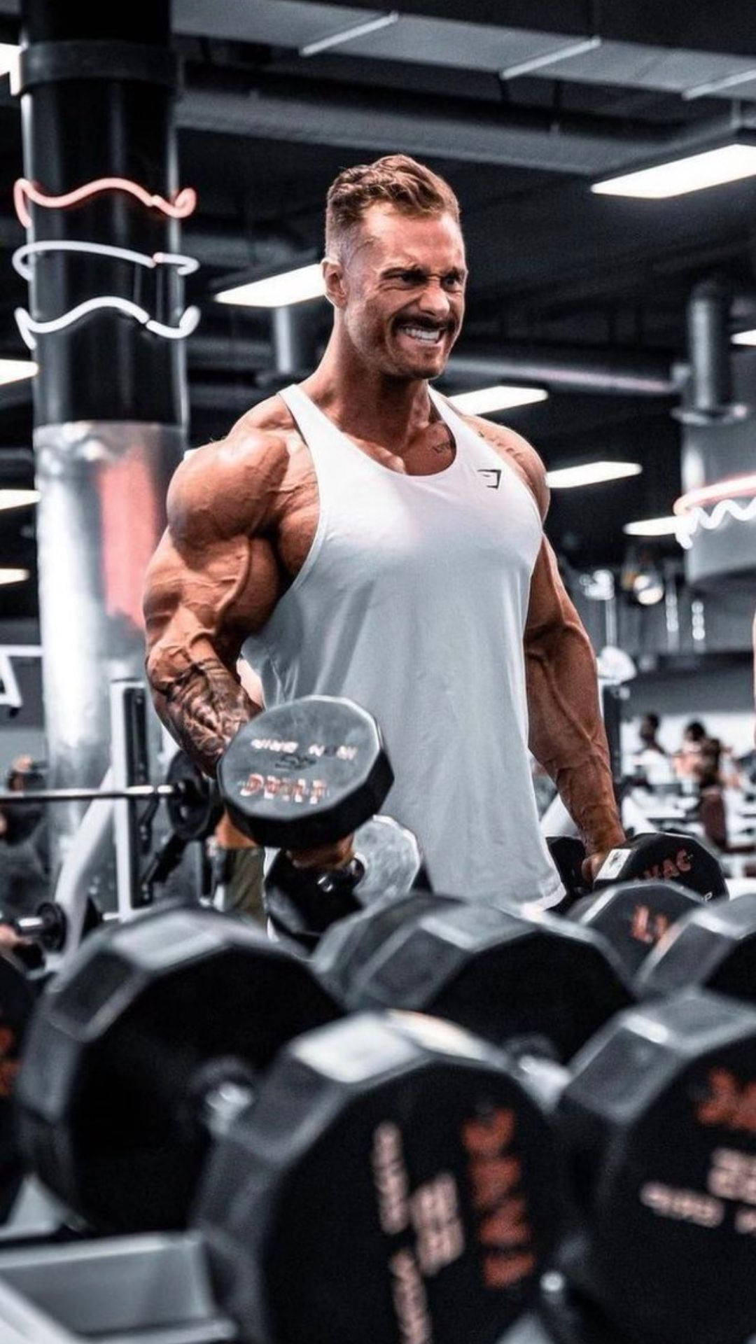 一位微笑的肌肉發達男子在霓虹燈健身房中舉啞鈴。