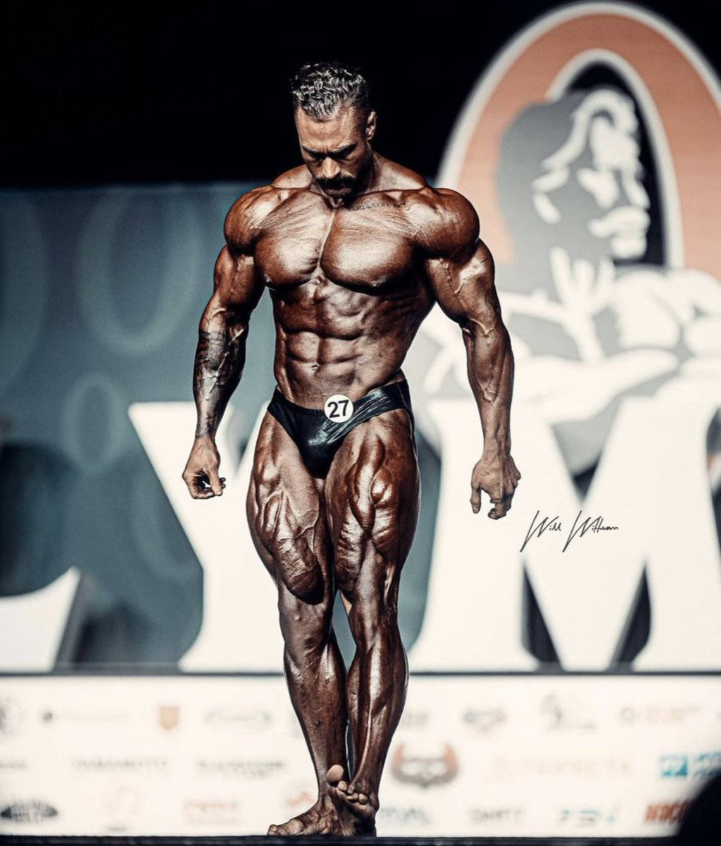 健美運動員27號在比賽期間在舞台上擺姿勢。