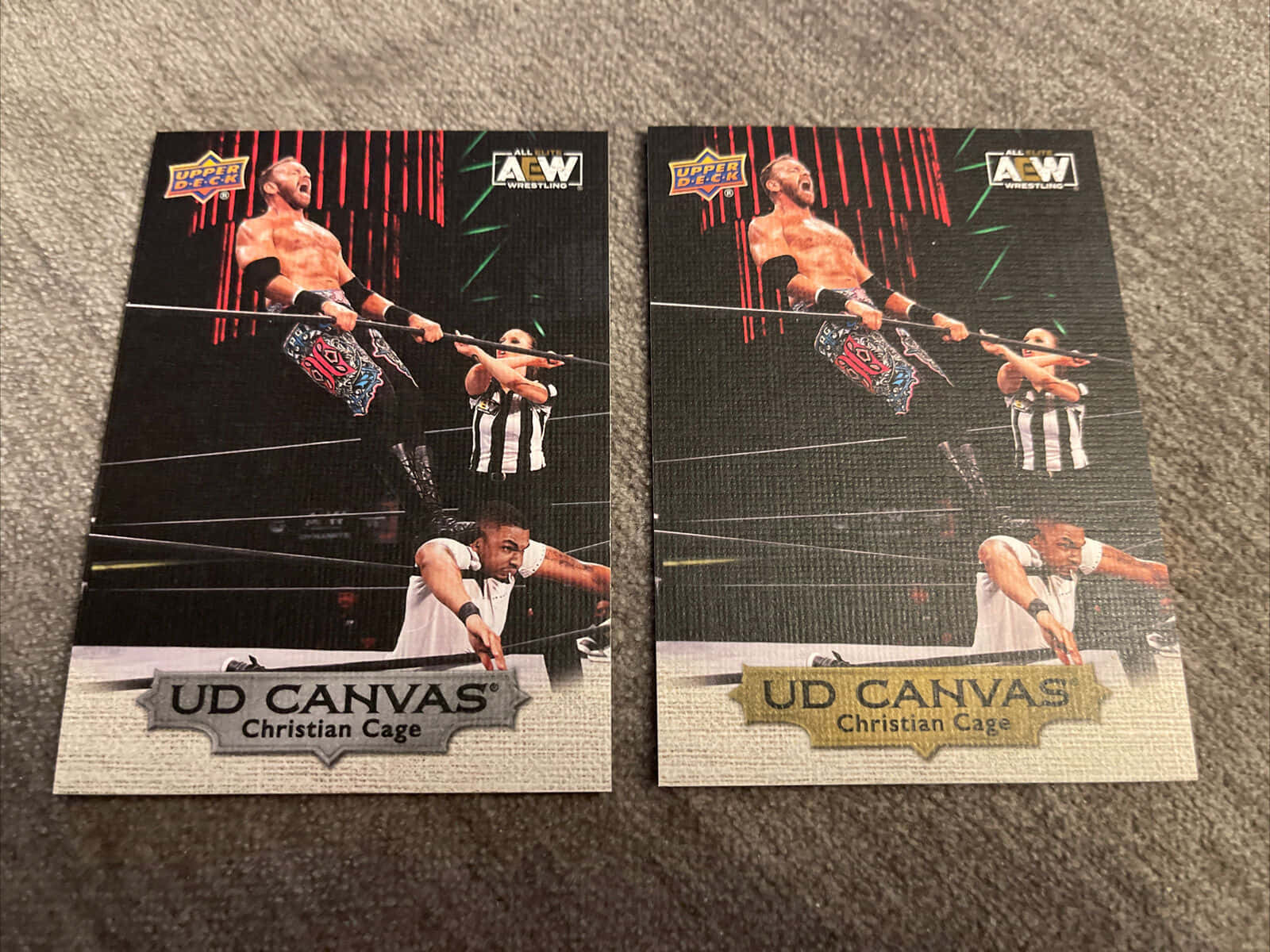 兩張AEW Christian Cage UD Canvas交易卡放在灰色地毯上。