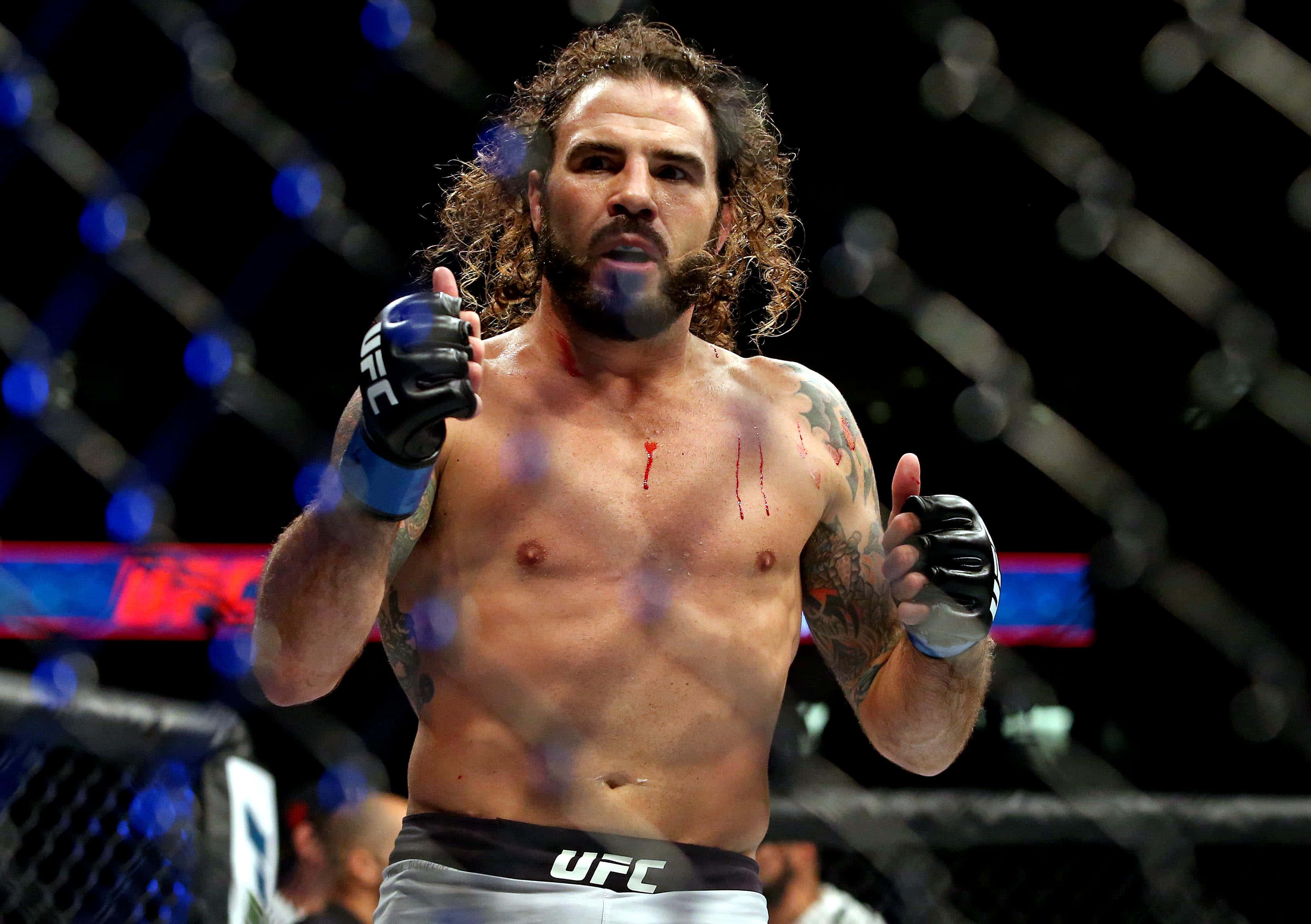 克雷頓·吉達於2017年UFC Fight Night對戰喬·勞森 壁紙 — 一名滿身鮮血、捲髮及紋身的UFC拳手在八角籠內高舉手套慶祝。