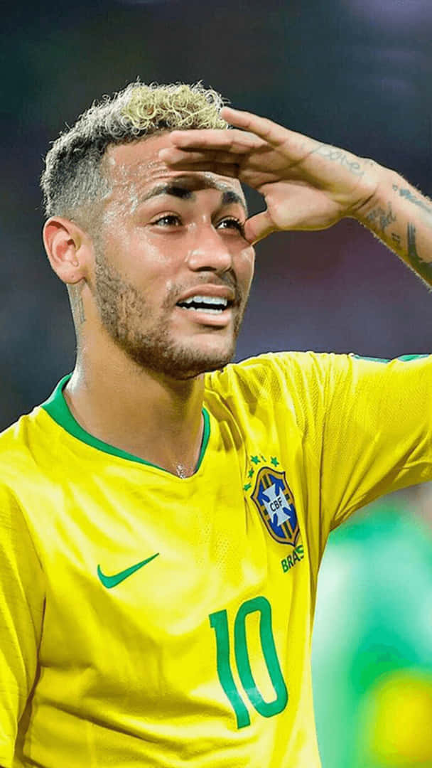 巴西足球運動員尼馬身穿黃色球衣在比賽中遮擋眼睛。