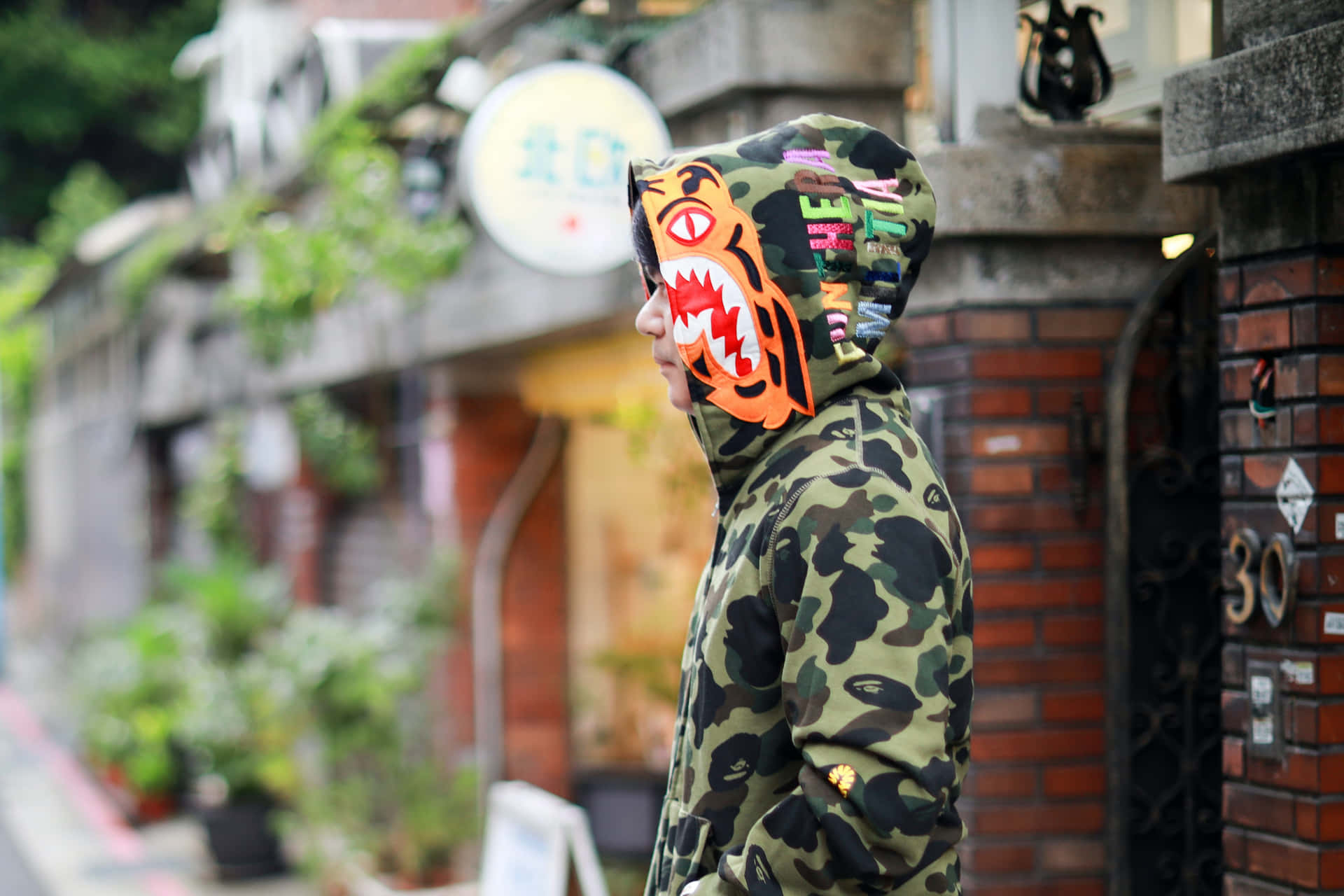 城市街道上身穿迷彩連帽衫和橙色鯊魚面罩的人。