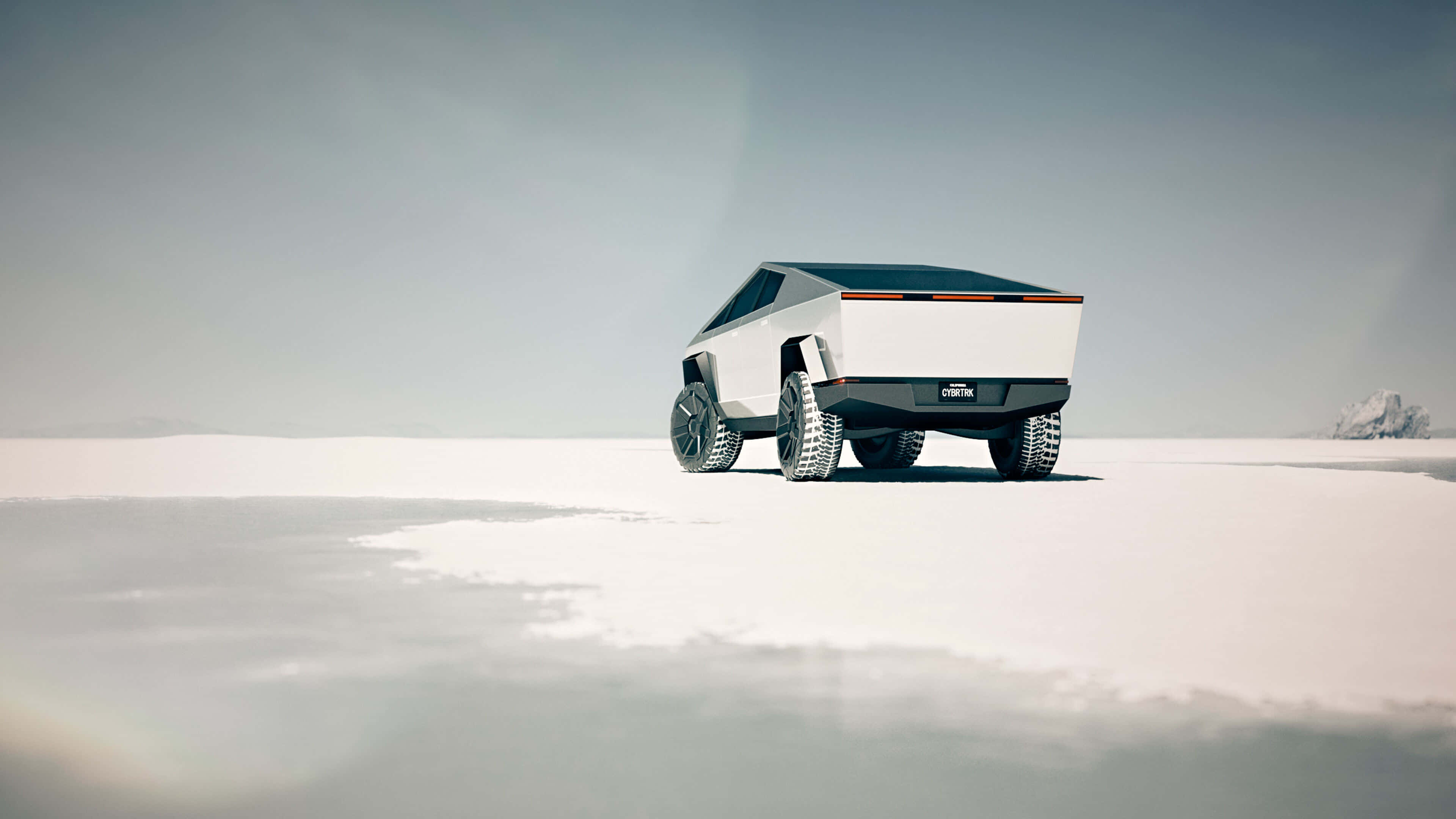 全新現代革命性特斯拉Cybertruck 壁紙 — 一架未來感十足的白色Tesla Cybertruck獨自停在一片廣闊的雪原上，天空蒼白，遠處有冰層結構。