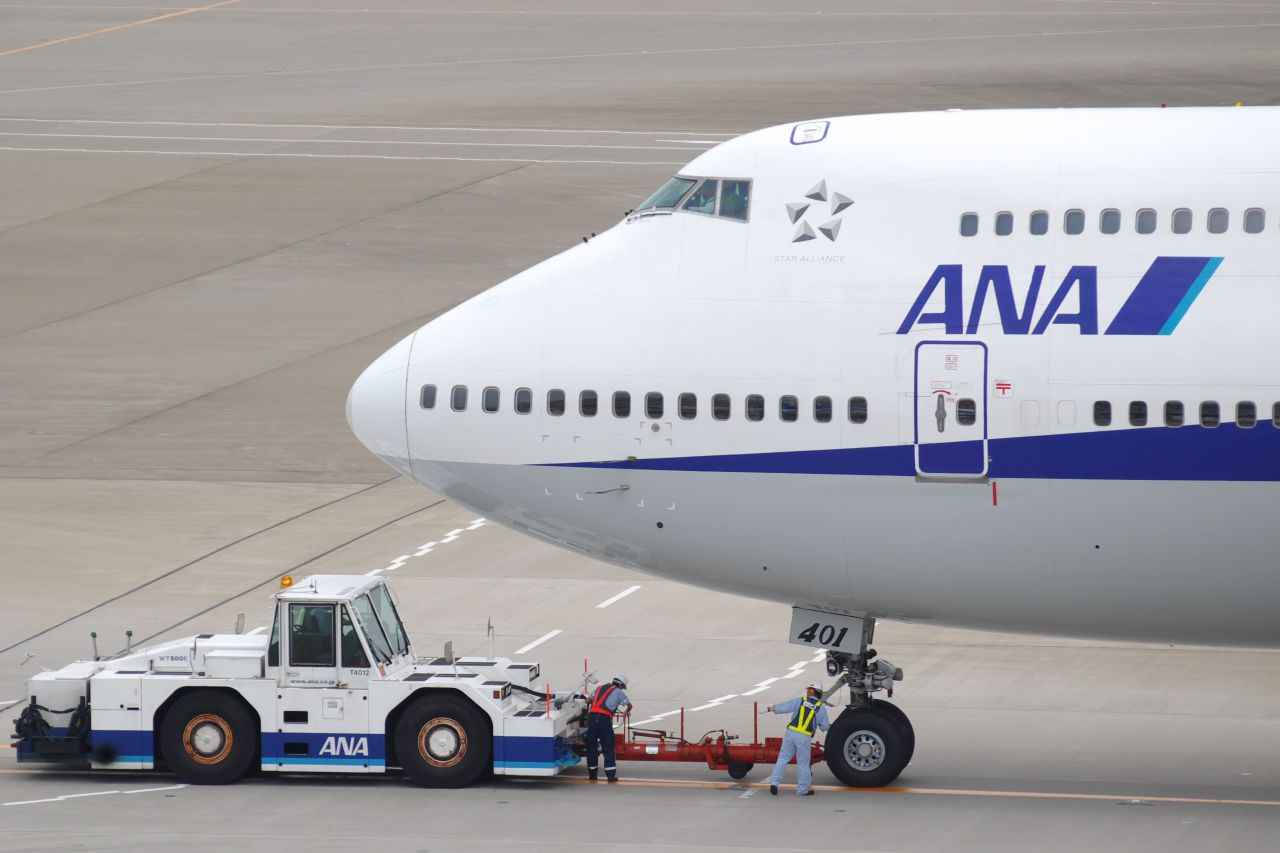 全日空飛機在機場停機坪上被地勤人員拖行。