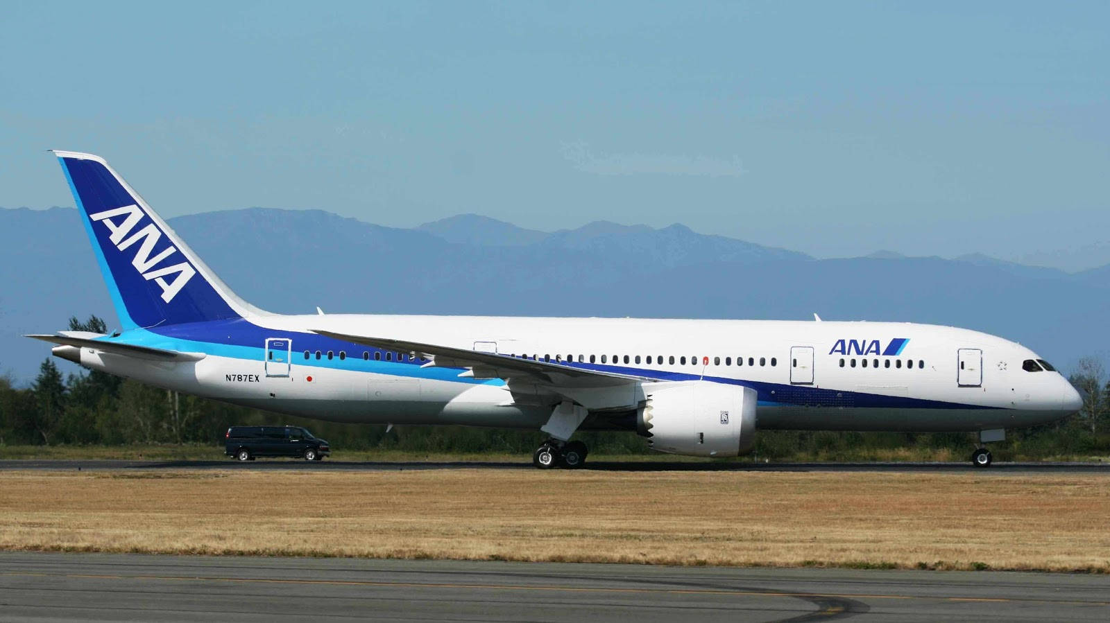 全日空飛機在跑道上，背景有山巒
