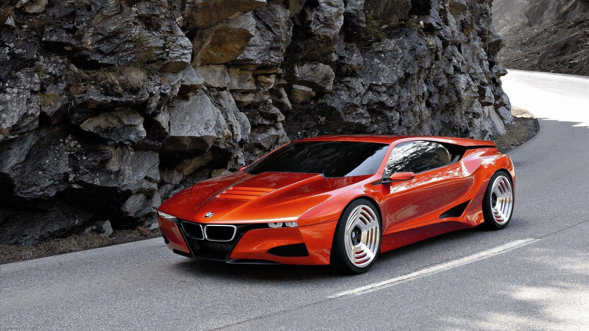 橙色BMW概念車在山路上，旁邊有岩石峭壁