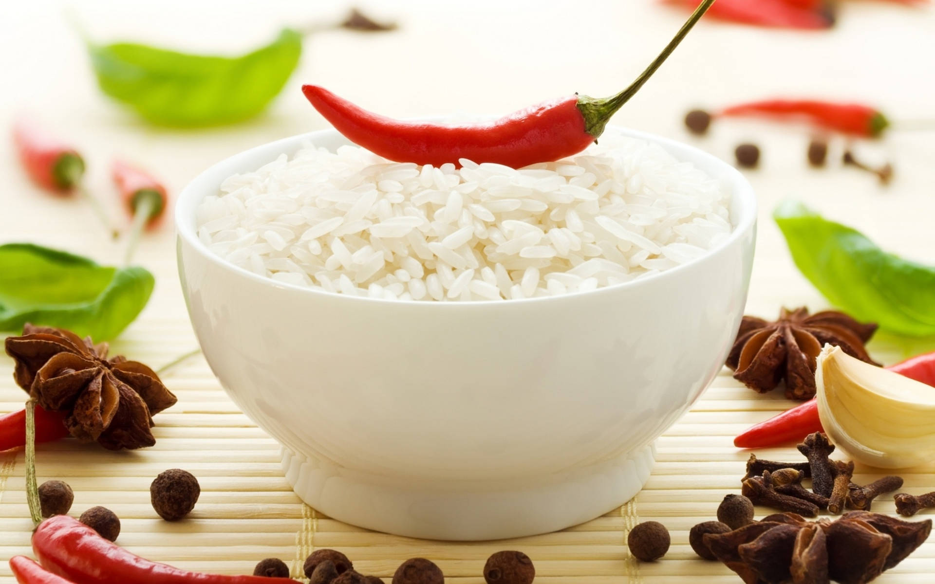 白色飯碗配紅辣椒和香料在竹蓆上