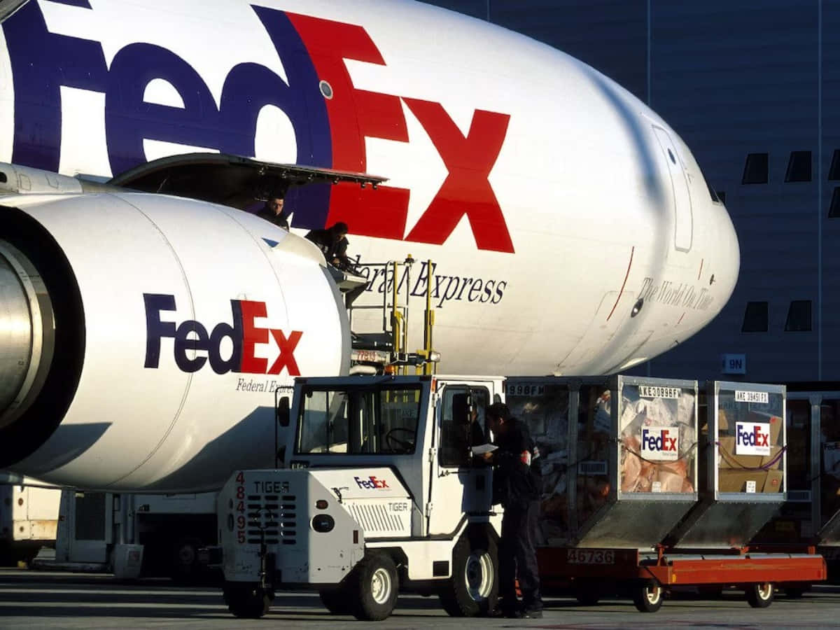 FedEx工人在機場將貨物裝上FedEx飛機。
