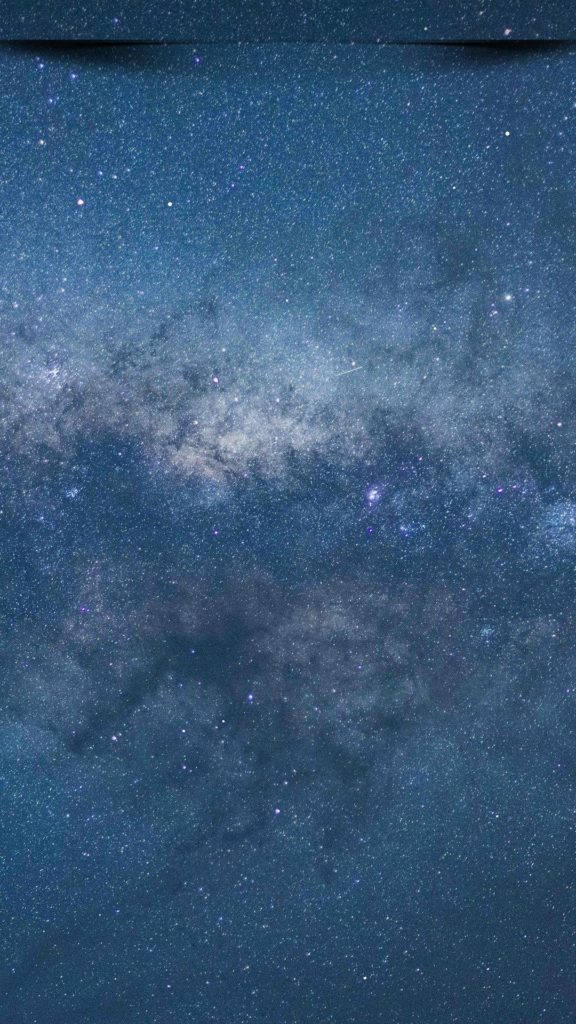 銀河系在深藍色和紫色的夜空中，佈滿星星和宇宙塵埃。