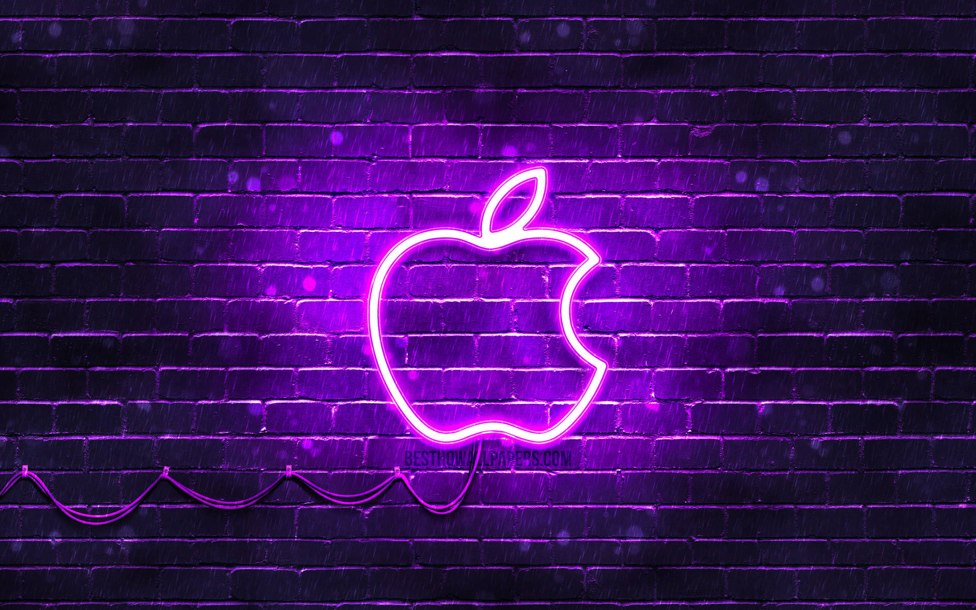 夜晚潮濕磚牆上的紫色霓虹燈Apple標誌。