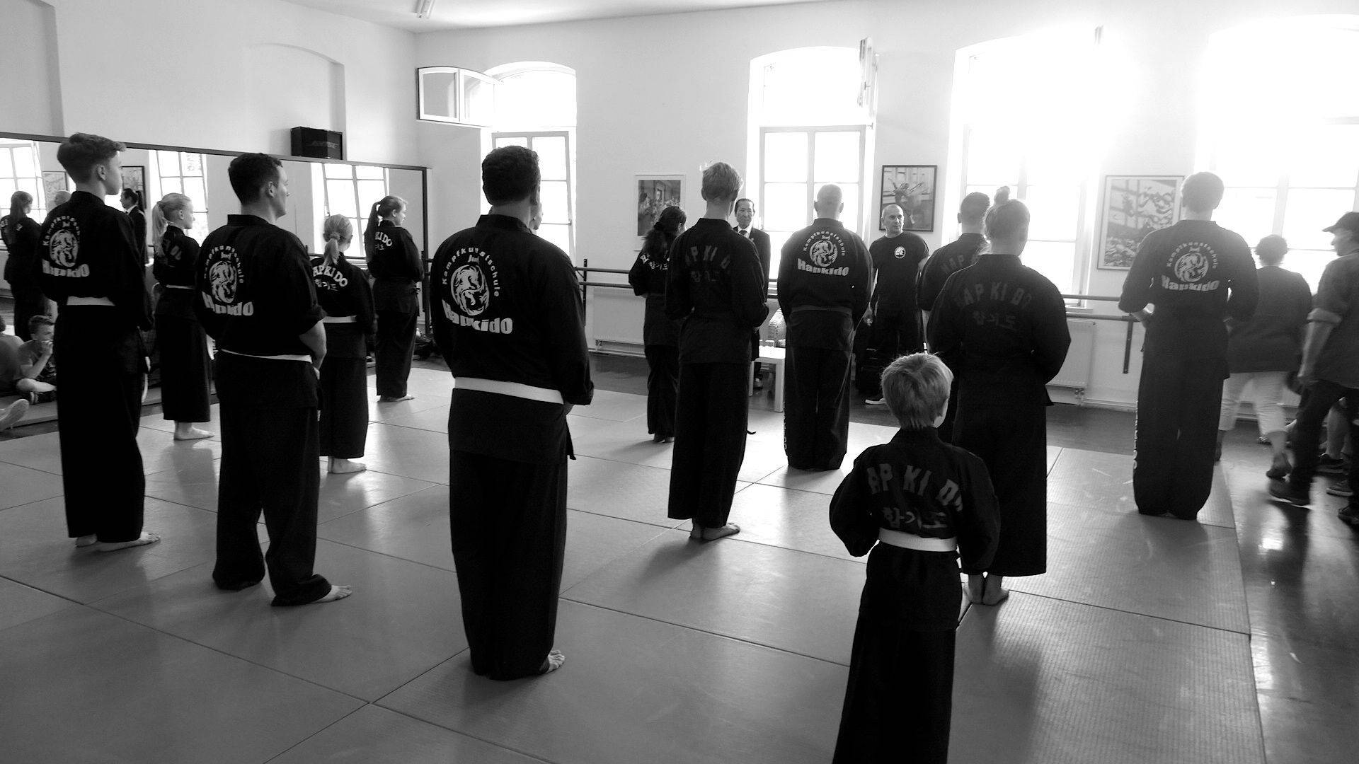 一群身穿黑色制服的武術學生站在道場中。