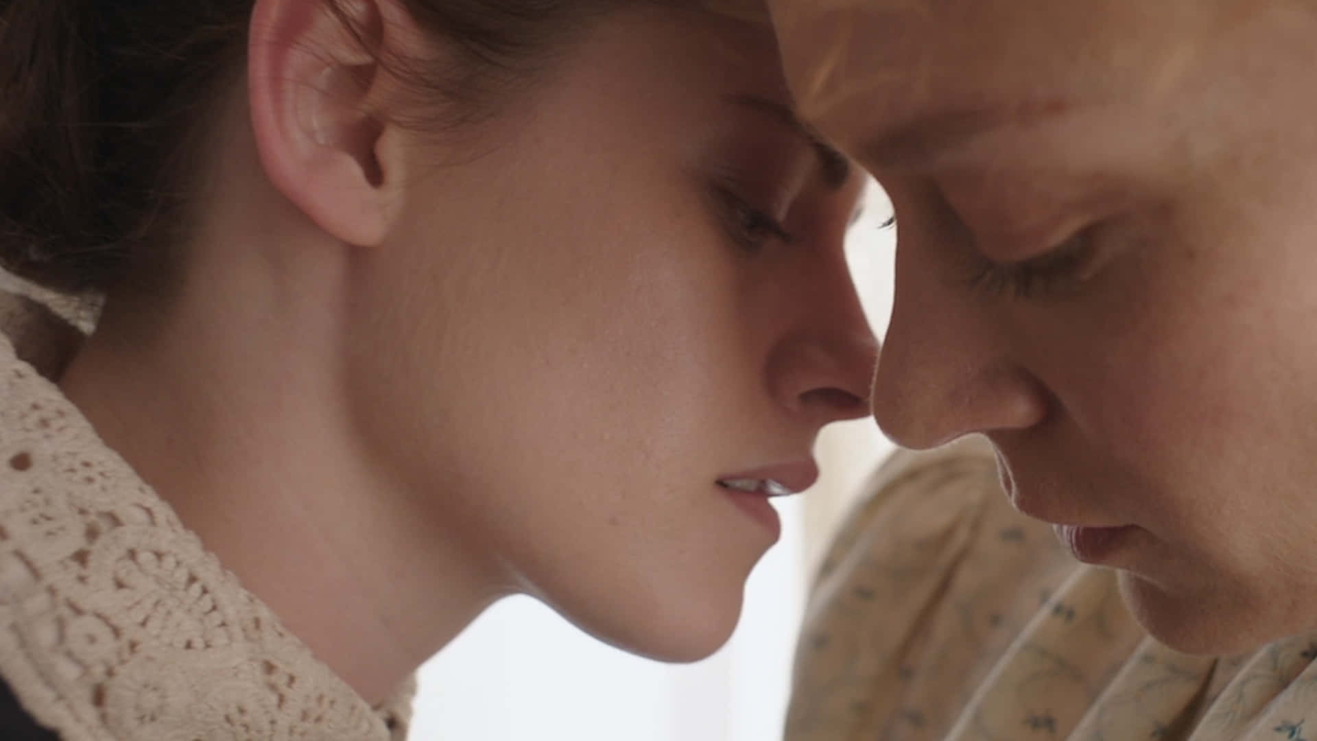 Chloë Sevigny 桌布 壁紙 — 兩位女性額頭相觸，在柔和溫暖的光線中享受溫柔親密的時刻。