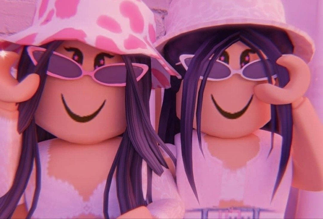 兩個戴著粉紅色帽子和太陽眼鏡的Roblox角色愉快地微笑。