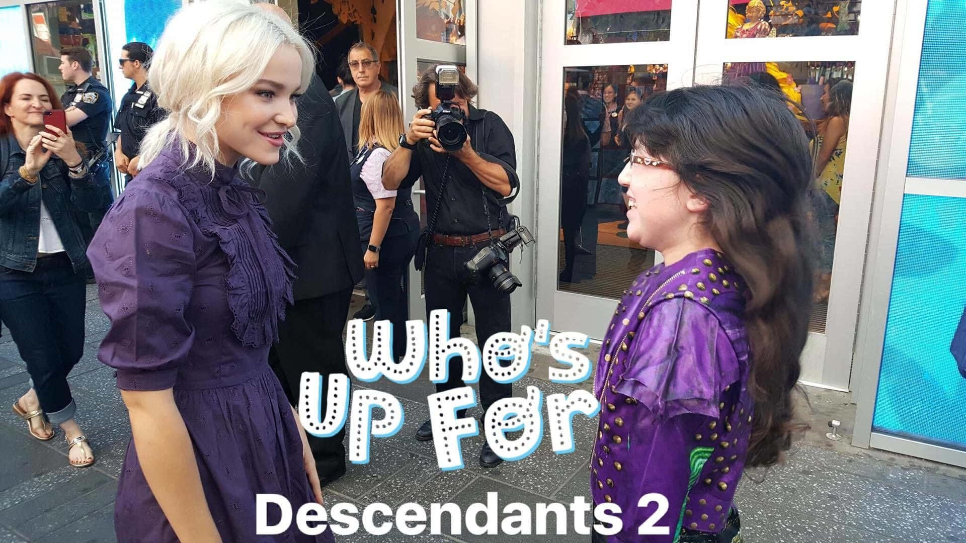 Descendants 桌布 壁紙 — 兩位年輕女性穿著相配的紫色連衣裙，在繁忙的城市人行道上微笑互動，進行推廣活動。