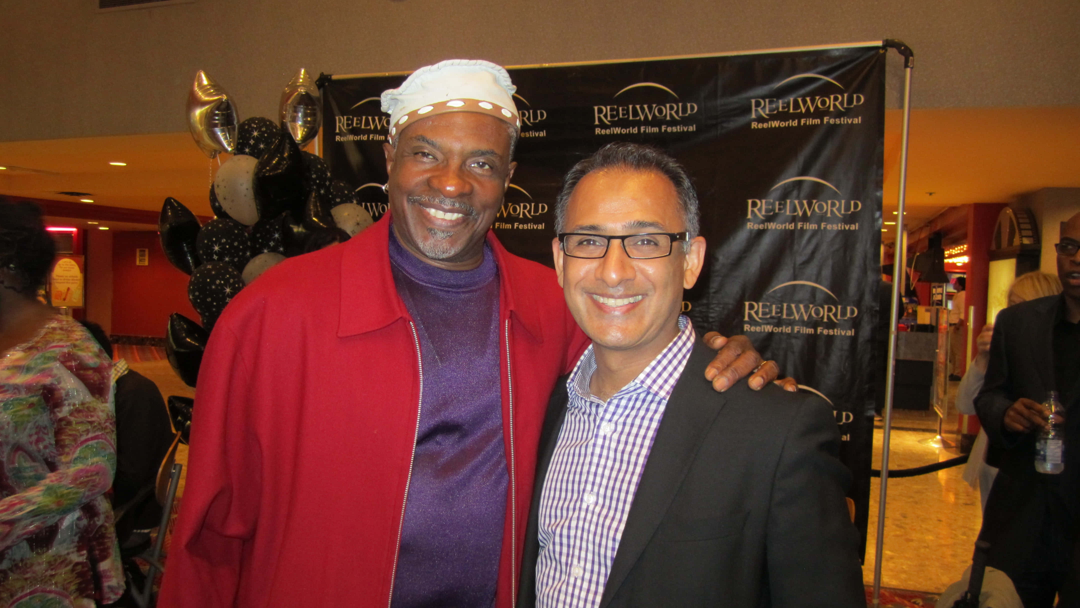 Keith David 桌布 壁紙 — 兩位微笑的男士在電影節上一起擺姿勢，身後有氣球和品牌背景。