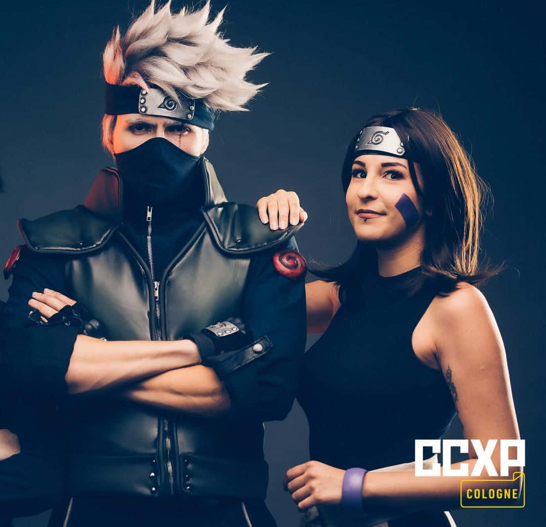 Kakashi And Rin 桌布 壁紙 — 兩位扮演《火影忍者》角色的Cosplayer在CCXP科隆的黑色攝影棚背景下自信地擺姿勢。