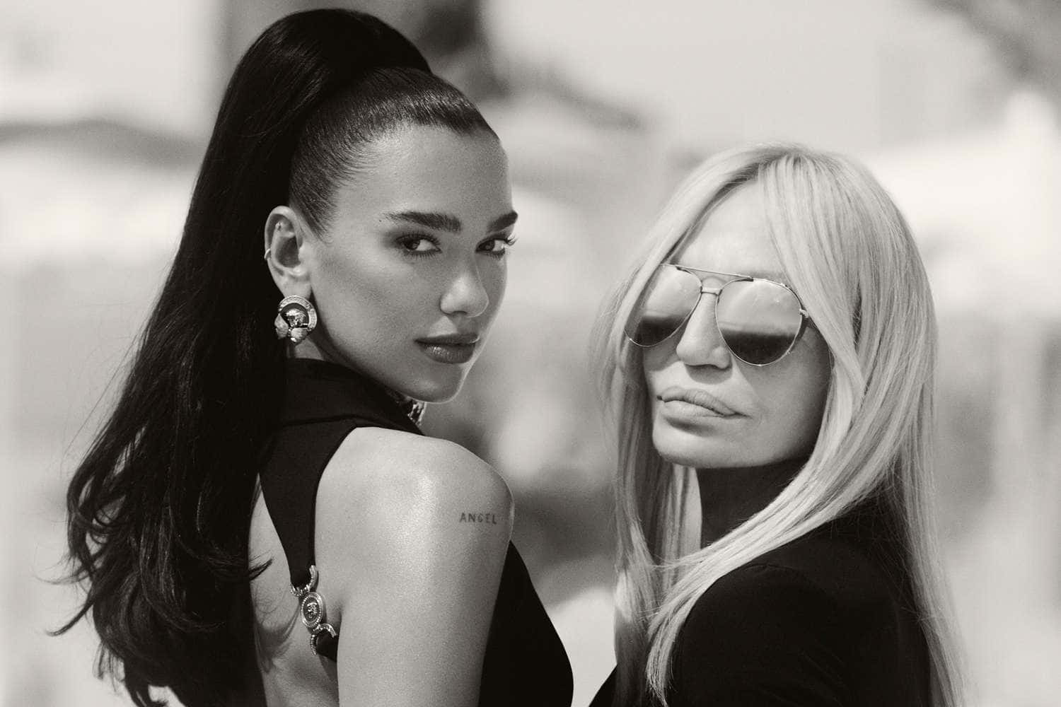 Black And White Fashion 桌布 壁紙 — 兩位時尚女性以黑白風格擺姿勢，一位深色頭髮，另一位金髮戴著太陽眼鏡。