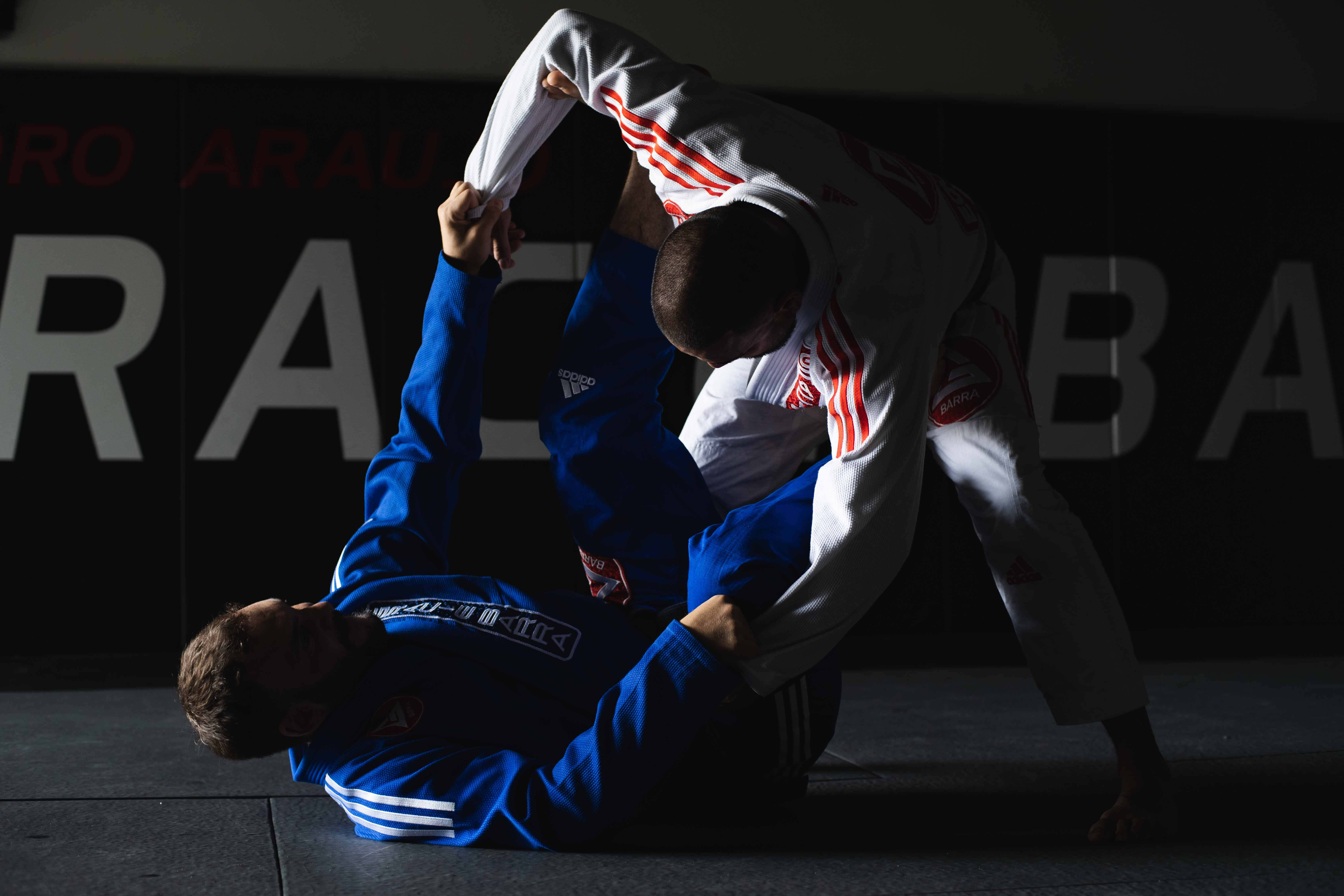Martial Arts Uniforms 桌布 壁紙 — 兩位武術家在戲劇性的工作室燈光下鎖定一個動態的纏鬥動作。