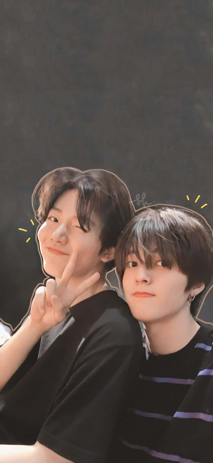 Aesthetic Korean 桌布 壁紙 — 兩位短黑髮的年輕男性在深色背景前俏皮地擺姿勢，一位眨眼並做出和平手勢，另一位則以平靜的表情向前看。