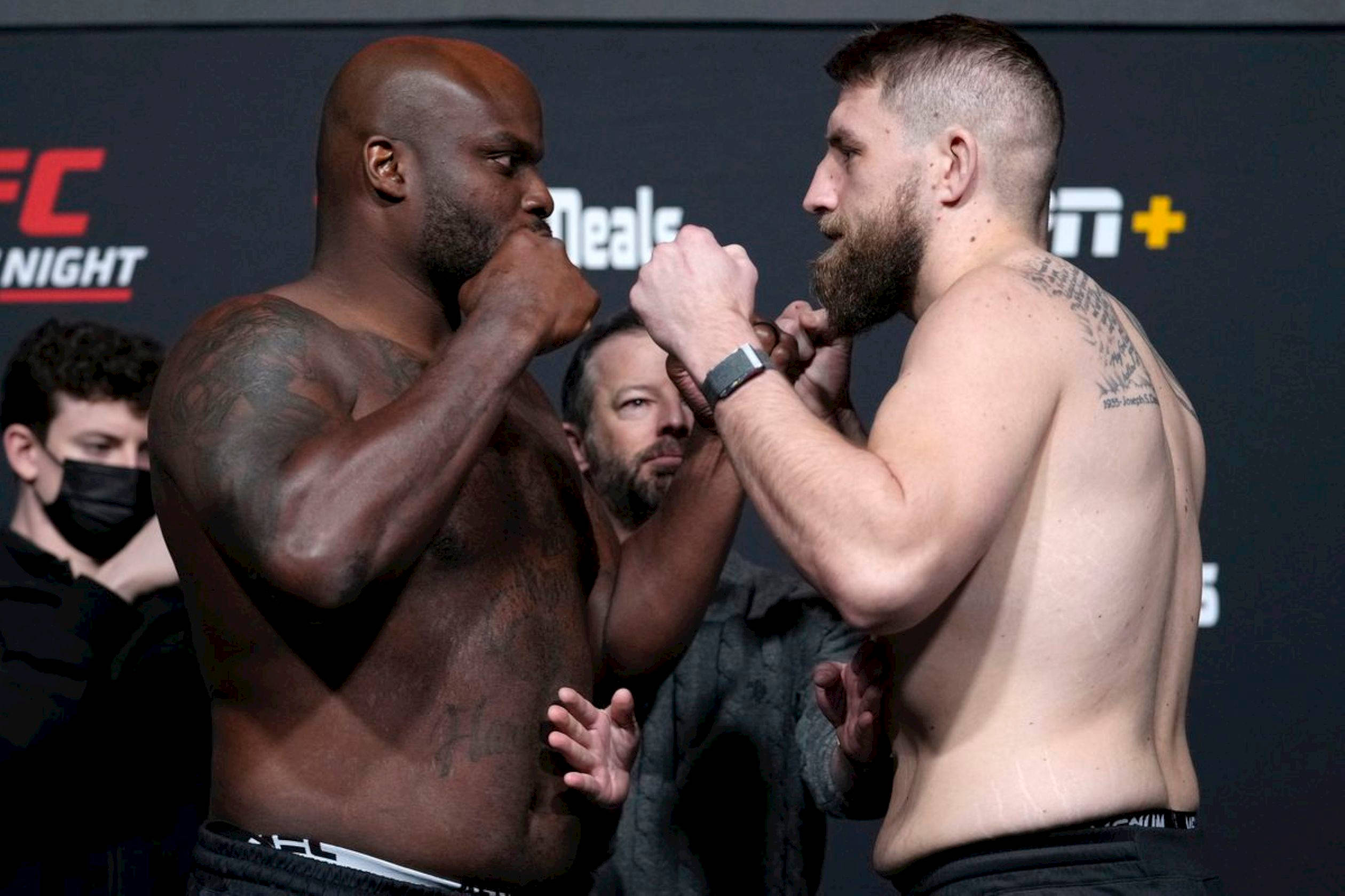 Chris Daukaus And Derrick Lewis Weigh-In 壁紙 — 兩位肌肉發達的UFC拳手在緊張的賽前對峙中舉起拳頭。