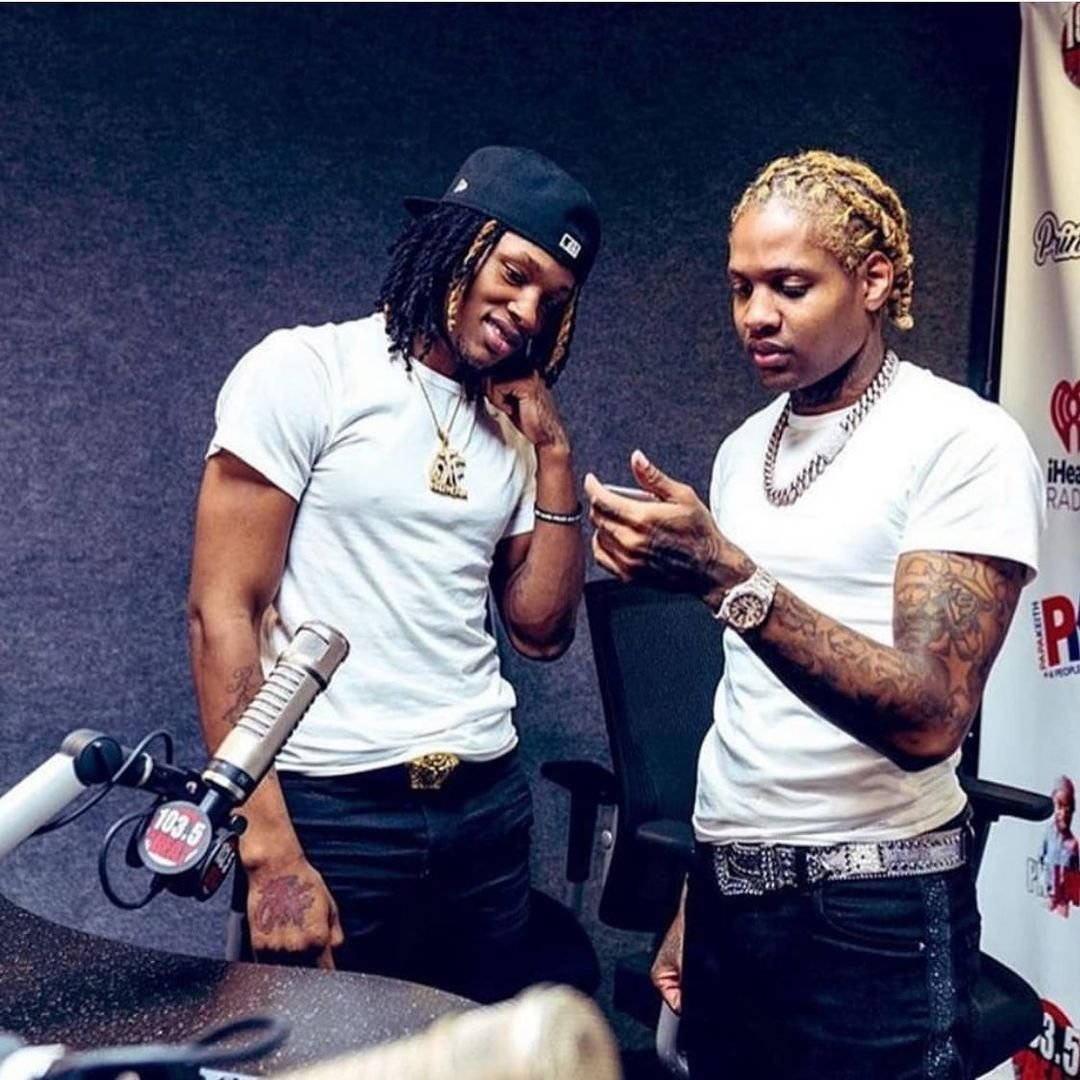 King Von And Lil Durk 桌布 壁紙 — 兩位身穿白色T恤和帽子的說唱歌手在錄音室裡俯身對著收音咪，一人微笑，另一人查看手機。