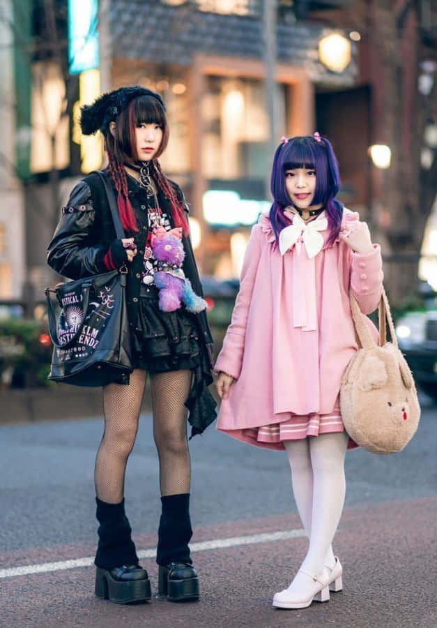 兩位身穿粉紅色服裝的女孩站在街上 壁紙