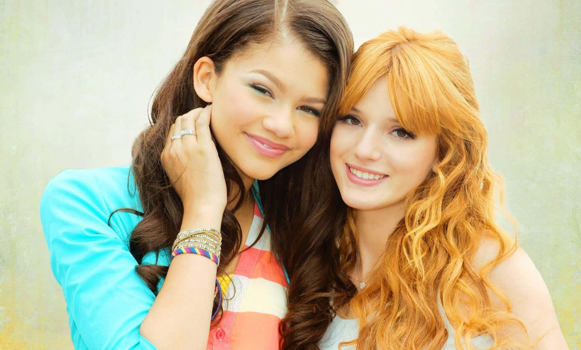 Zendaya 桌布 壁紙 — 兩位長髮微笑的年輕女性在柔軟紋理背景前緊密擺姿勢。
