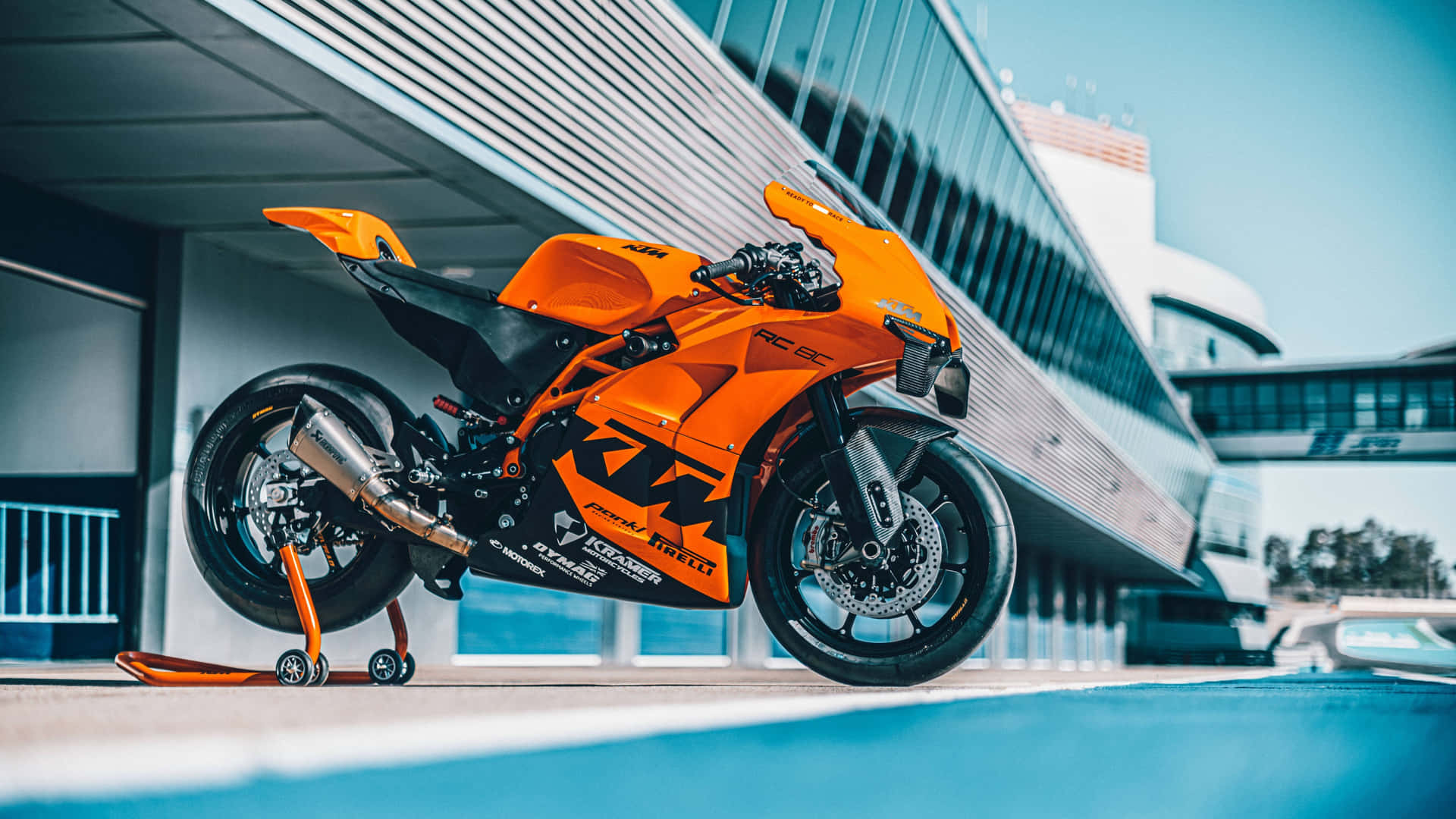 橙色KTM RC 660電單車停放在現代建築下