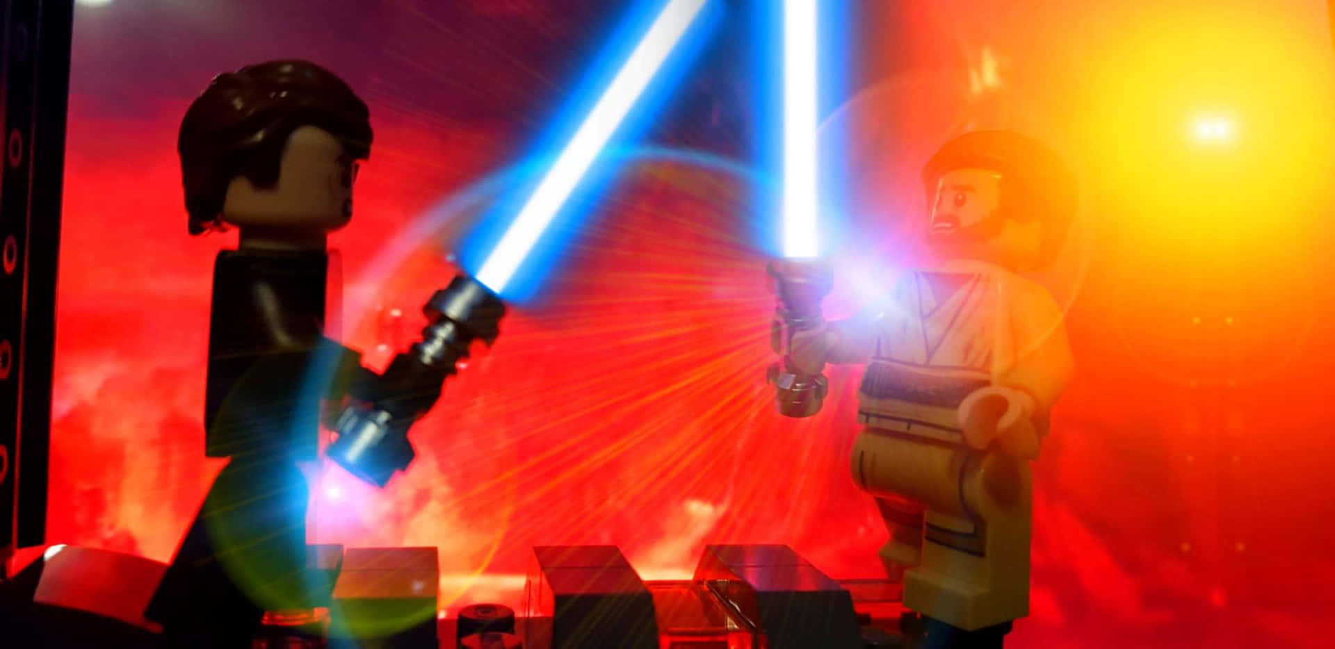 The Battle Of The Heroes 桌布 壁紙 — 兩個LEGO 星球大戰人偶在熾熱的紅色和橙色背景下，用發光的藍色光劍決鬥。