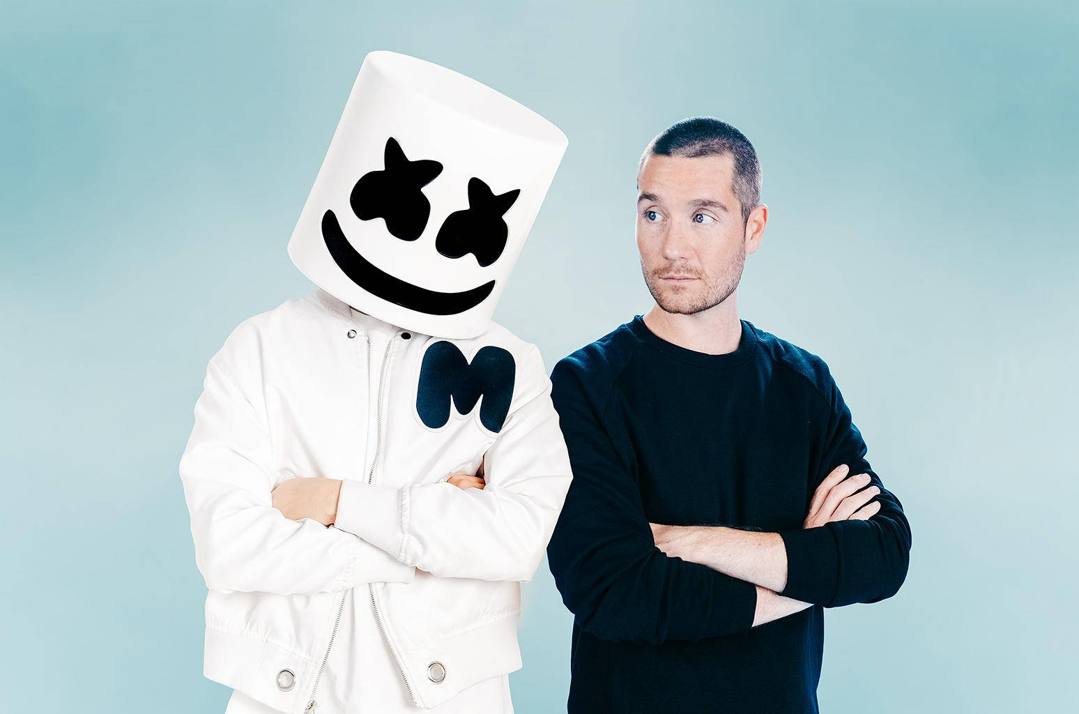 Marshmello ft. Bastille 壁紙 — 兩個人影並肩而立，一人戴著白色棉花糖頭盔，上有笑臉圖案，另一人穿著黑色毛衣，兩人均交叉雙臂，背景為柔和藍色。