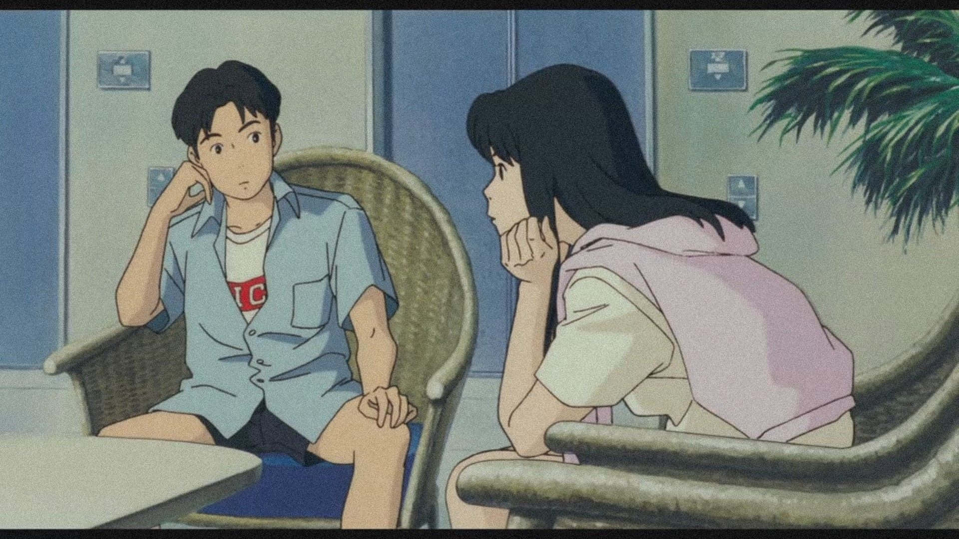 Studio Ghibli Ocean Waves 桌布 壁紙 — 兩個動漫青少年在寧靜的咖啡店裡隔著桌子相對而坐，在柔和的藍色燈光下分享一個深思的時刻。