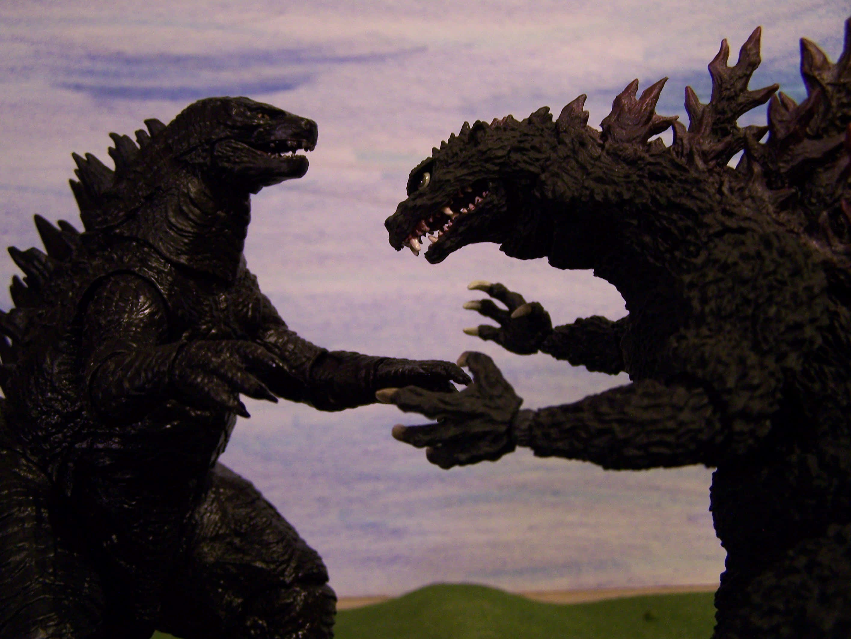 godzilla 1998 桌布 壁紙 — 兩個哥斯拉動作人偶在繪畫的天空背景下戲劇性地對峙。