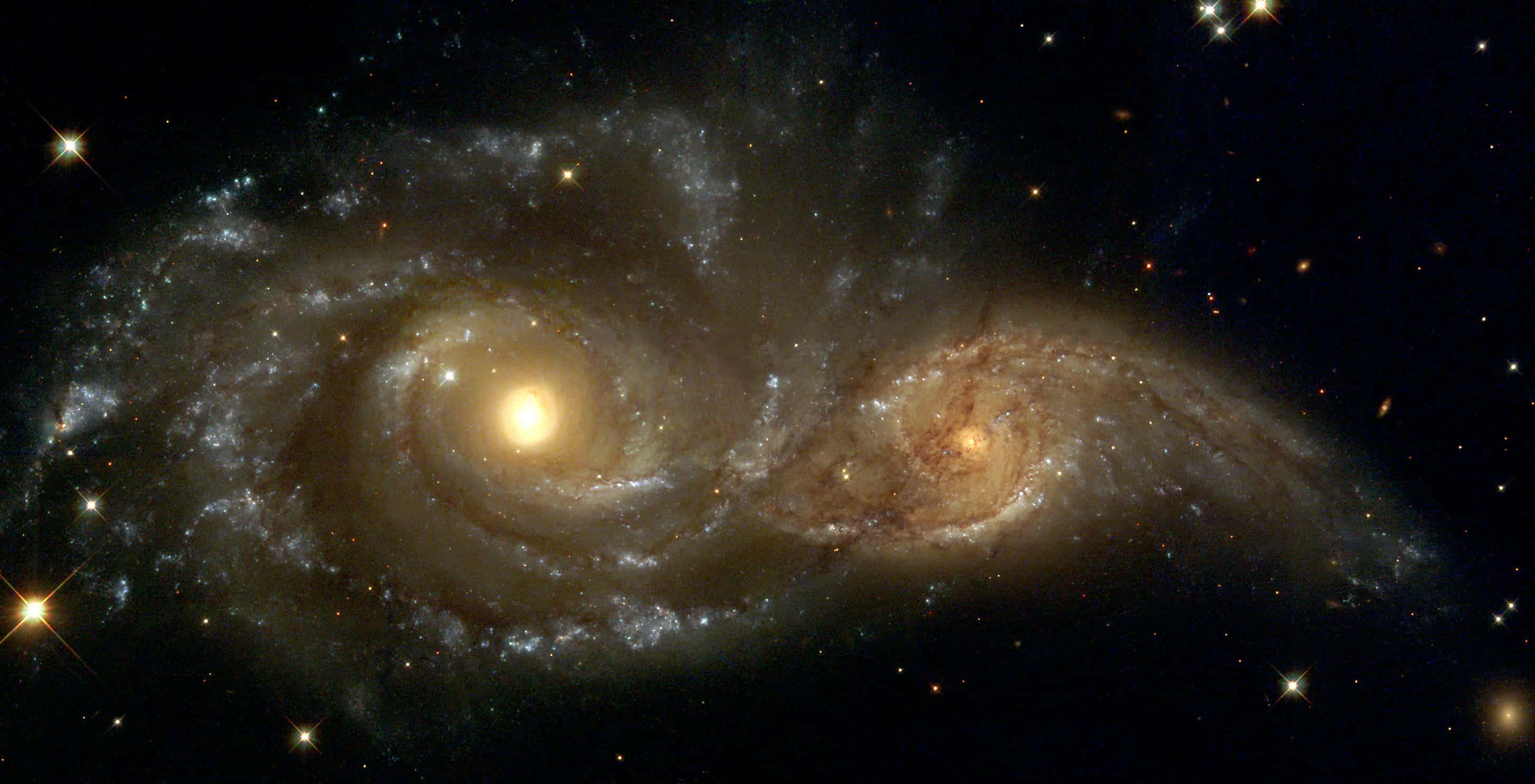Deep Space 桌布 壁紙 — 兩個宏偉的螺旋星系在佈滿星光的黑色虛空中進行宇宙舞蹈般的碰撞。