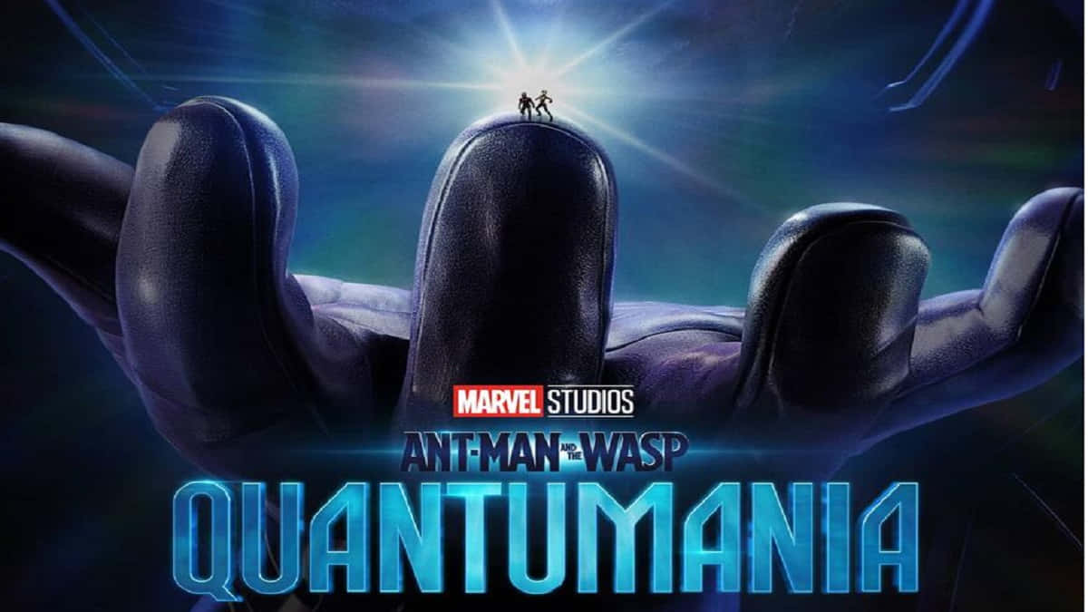 Quantum Realm 桌布 壁紙 — 兩個微型超級英雄站在一隻巨手的拇指上，背景是帶有發光射線的宇宙藍色和紫色。