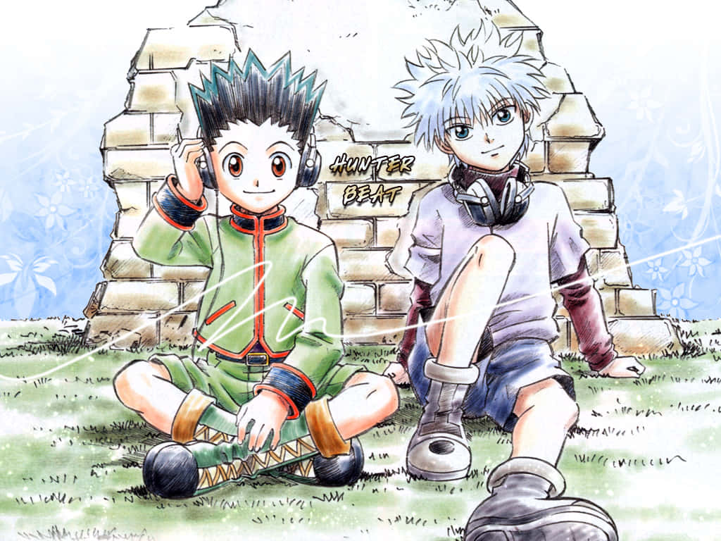 Shonen Anime 桌布 壁紙 — 兩個戴住耳機嘅動畫男仔喺藍天底下嘅石頭廢墟前交叉腳坐喺草地上。