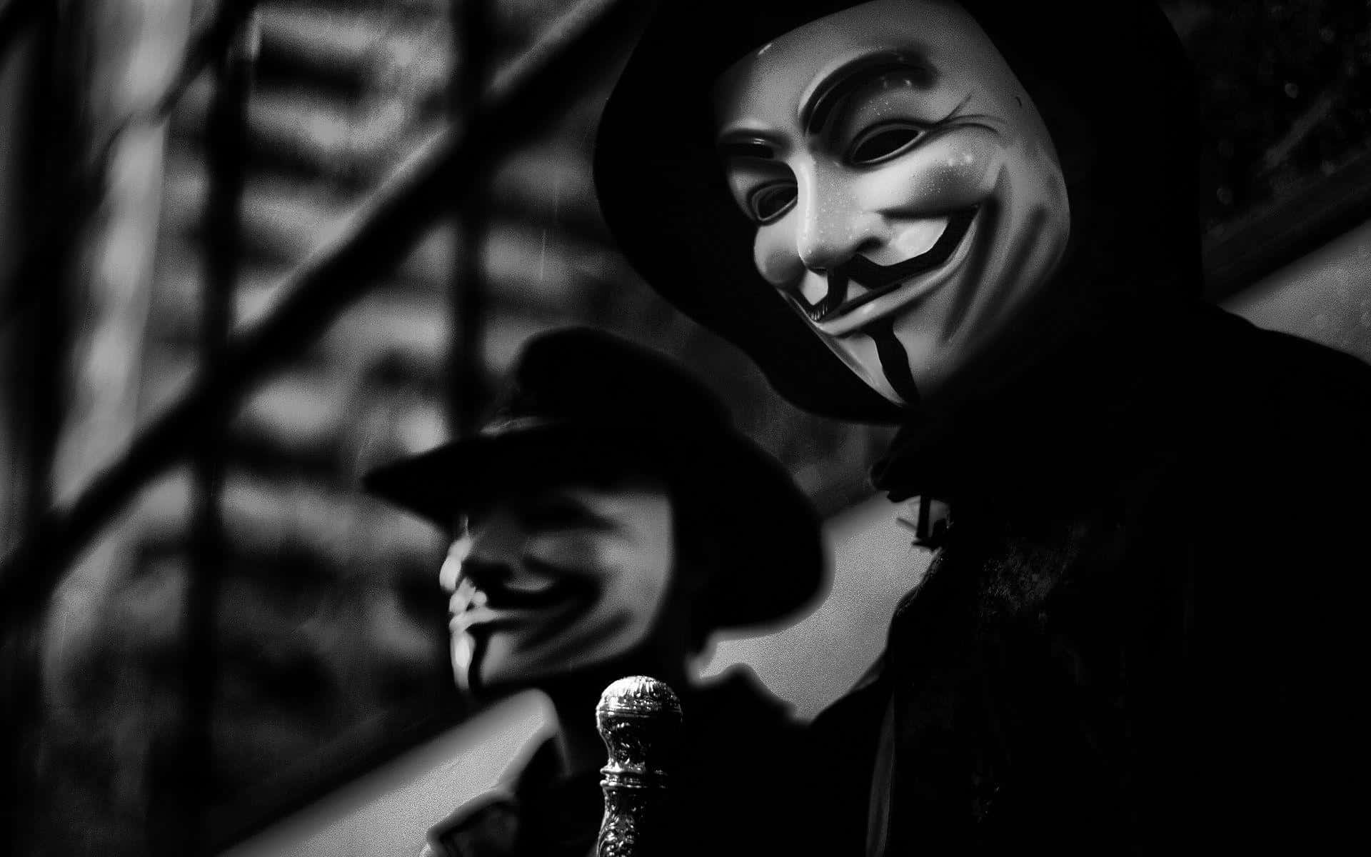 Anonymous 桌布 壁紙 — 兩個戴著蓋伊·福克斯面具的人物站在陰暗的城市小巷中，帶有戲劇性的高對比度燈光。