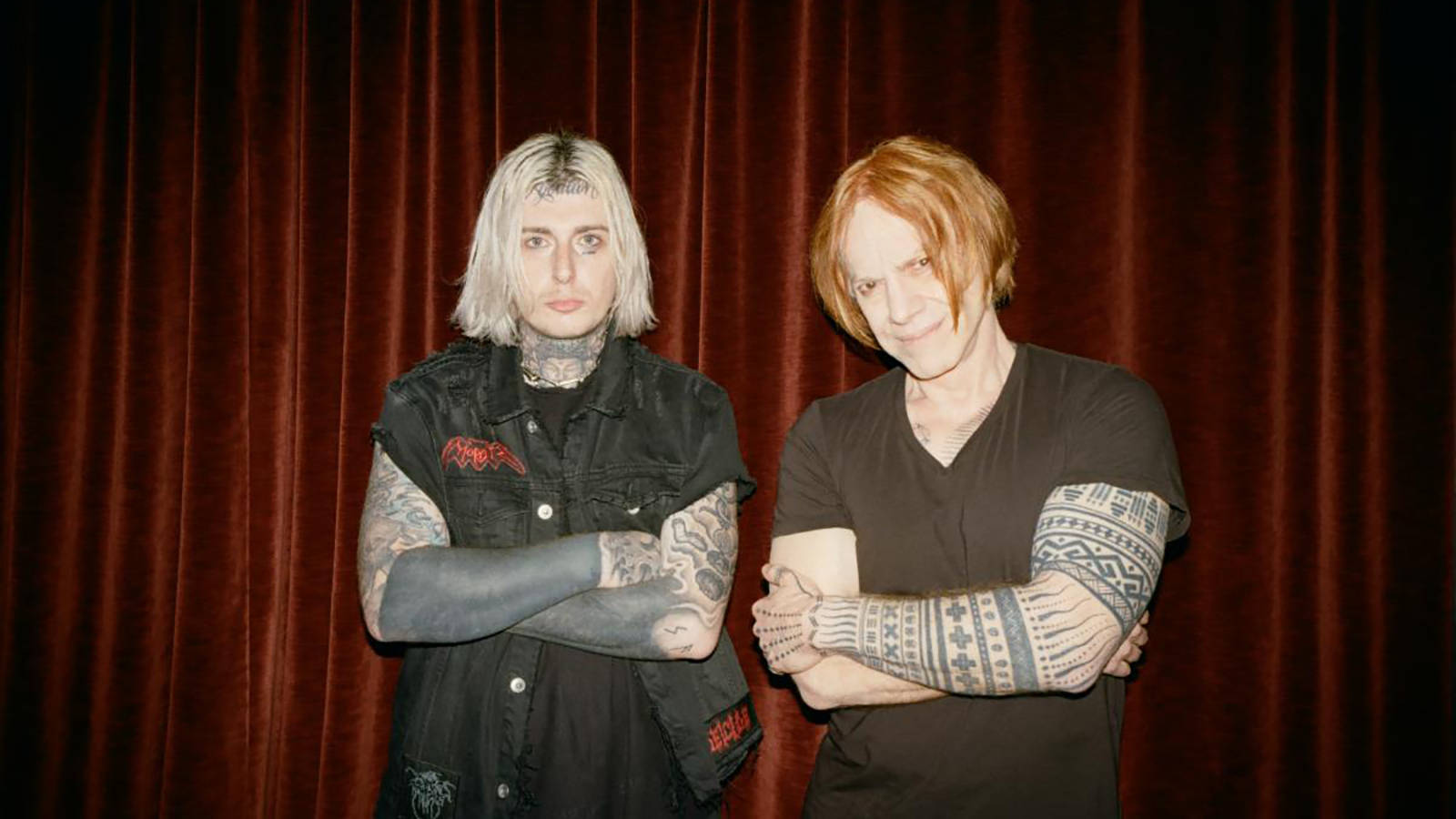 Ghostemane 桌布 壁紙 — 兩個有紋身、化著蒼白妝容、交叉雙臂的人站在深紅色天鵝絨窗簾前。
