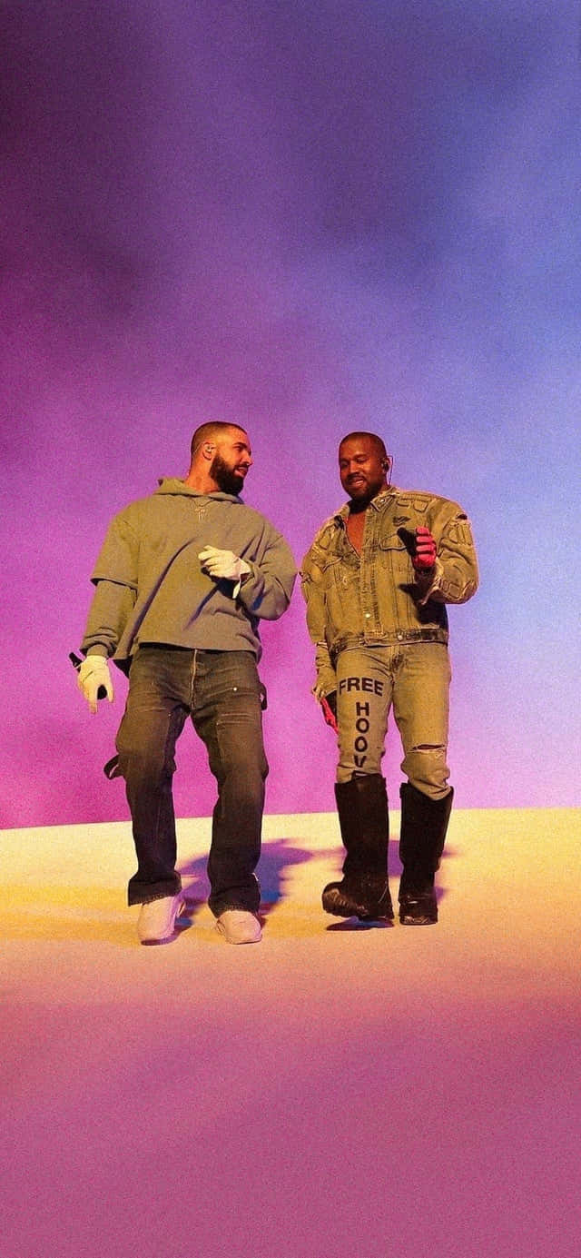 Drake 桌布 壁紙 — 兩個男人站在一個燈光璀璨的舞台上，背景是漸變的紫色和藍色天空，穿著休閒街頭服飾。