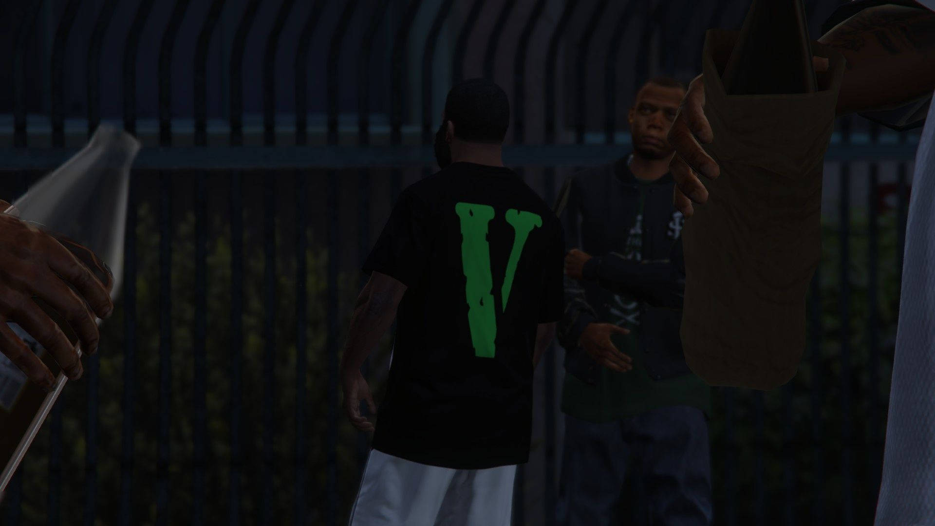 GTA 5 VLONE 壁紙 — 兩個男人站在昏暗的光線下靠近圍欄，一個穿著帶有綠色V標誌的黑色襯衫，另一個拿著一個棕色袋子。