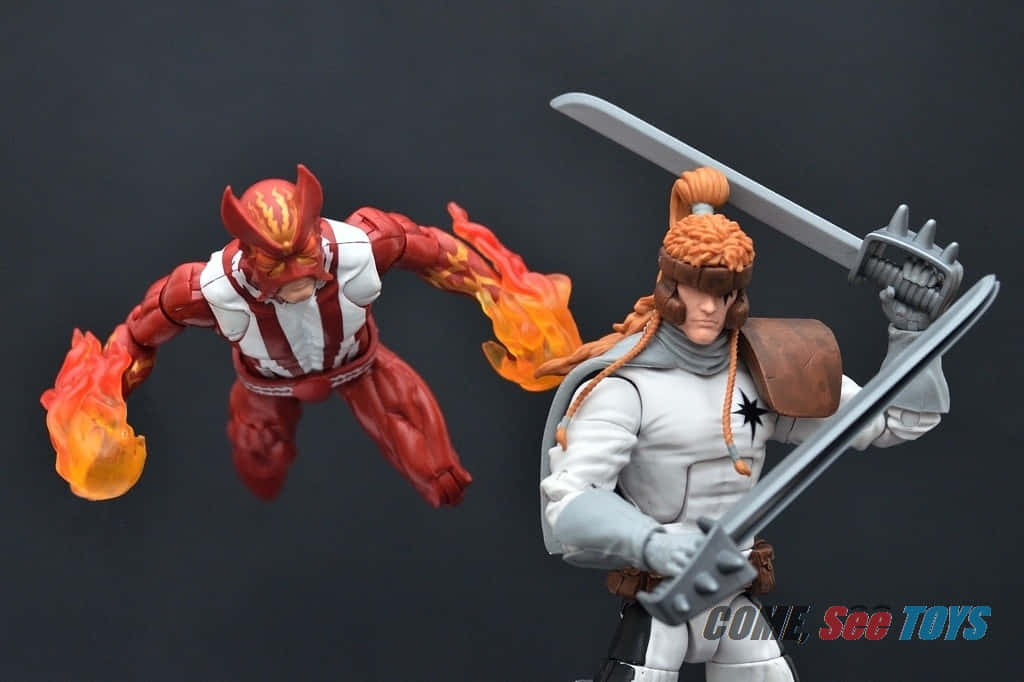 Shatterstar 桌布 壁紙 — 兩個精細嘅動作人偶，一個係火紅色帶火焰，另一個係白色盔甲持劍，喺深色背景前動態擺姿勢。