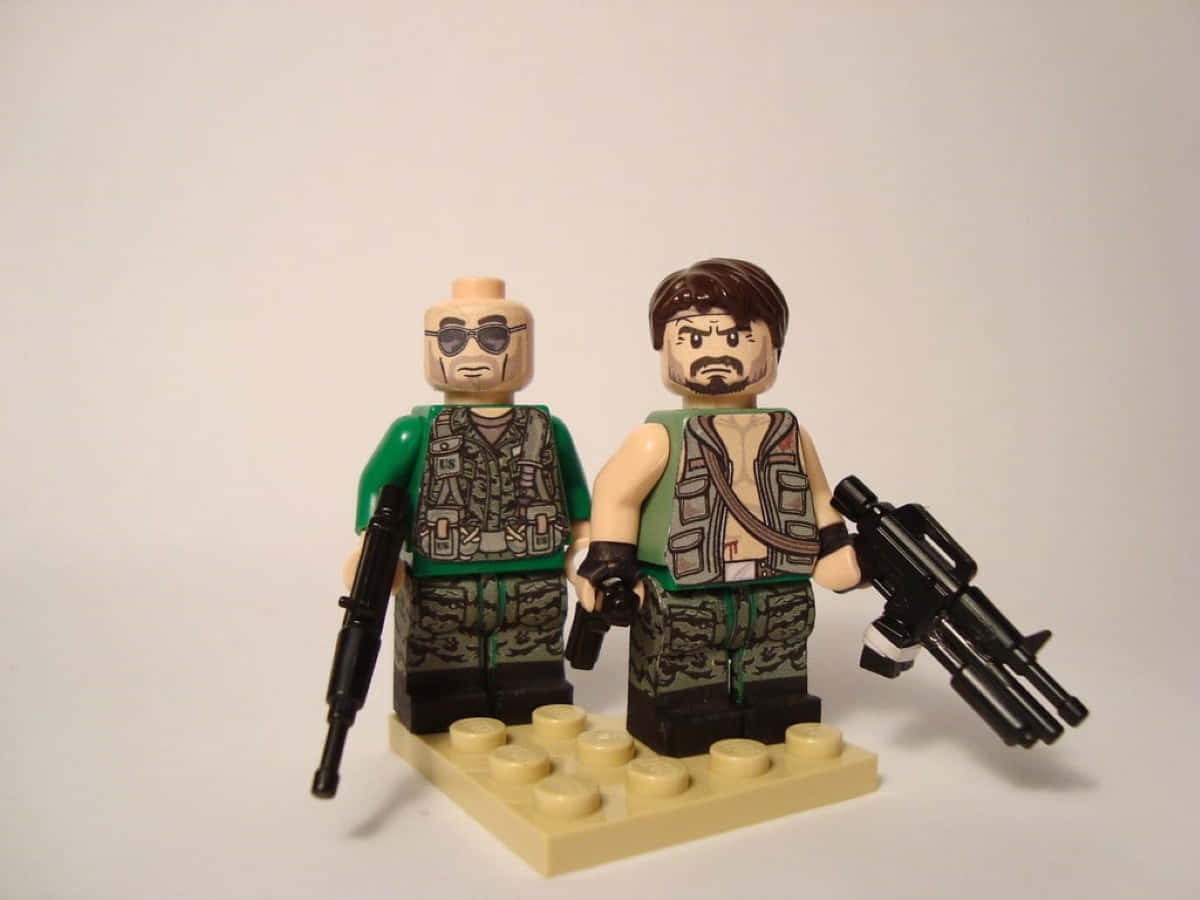 Frank Woods 桌布 壁紙 — 兩個身穿軍裝的LEGO人仔並排站立，手持槍械，位於淺褐色底板上，背景為純白色。