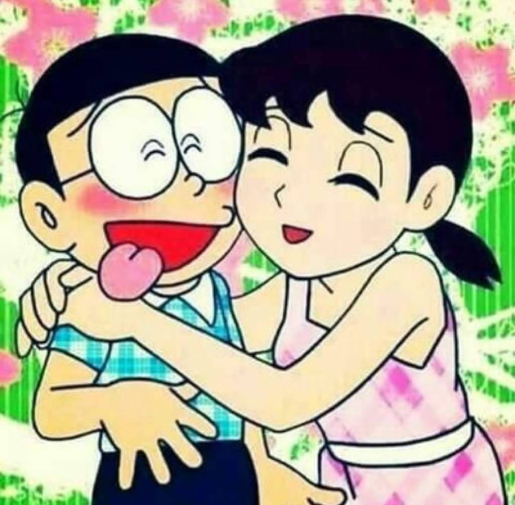 nobita shizuka love 桌布 壁紙 — 兩個開心的動漫角色在帶有明亮粉紅色和綠色色調的花卉背景前頑皮地擁抱。