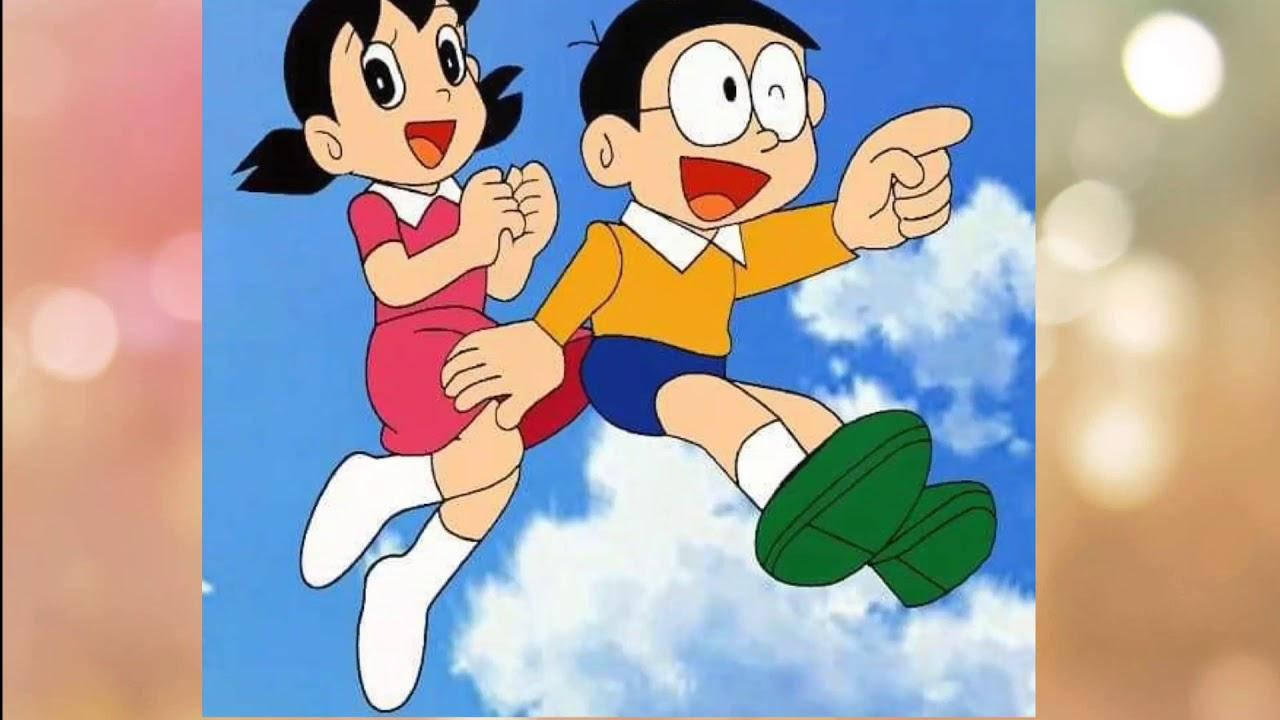 Doraemon 桌布 壁紙 — 兩個開心的動畫小孩在明亮的藍天中飛翔，伴隨著蓬鬆的白雲，咧嘴笑著並興奮地指著。